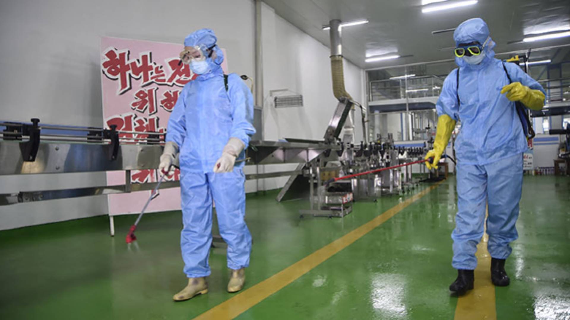 يقوم مسؤولو الصحة بتطهير أرضية مكان العمل - AFP