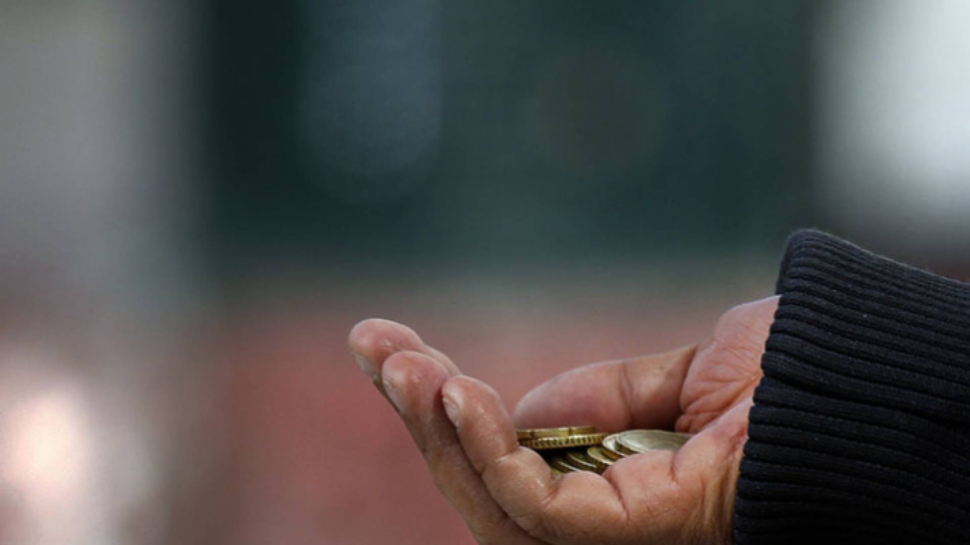 صورة توضيحية لمتسول وبيده نقود