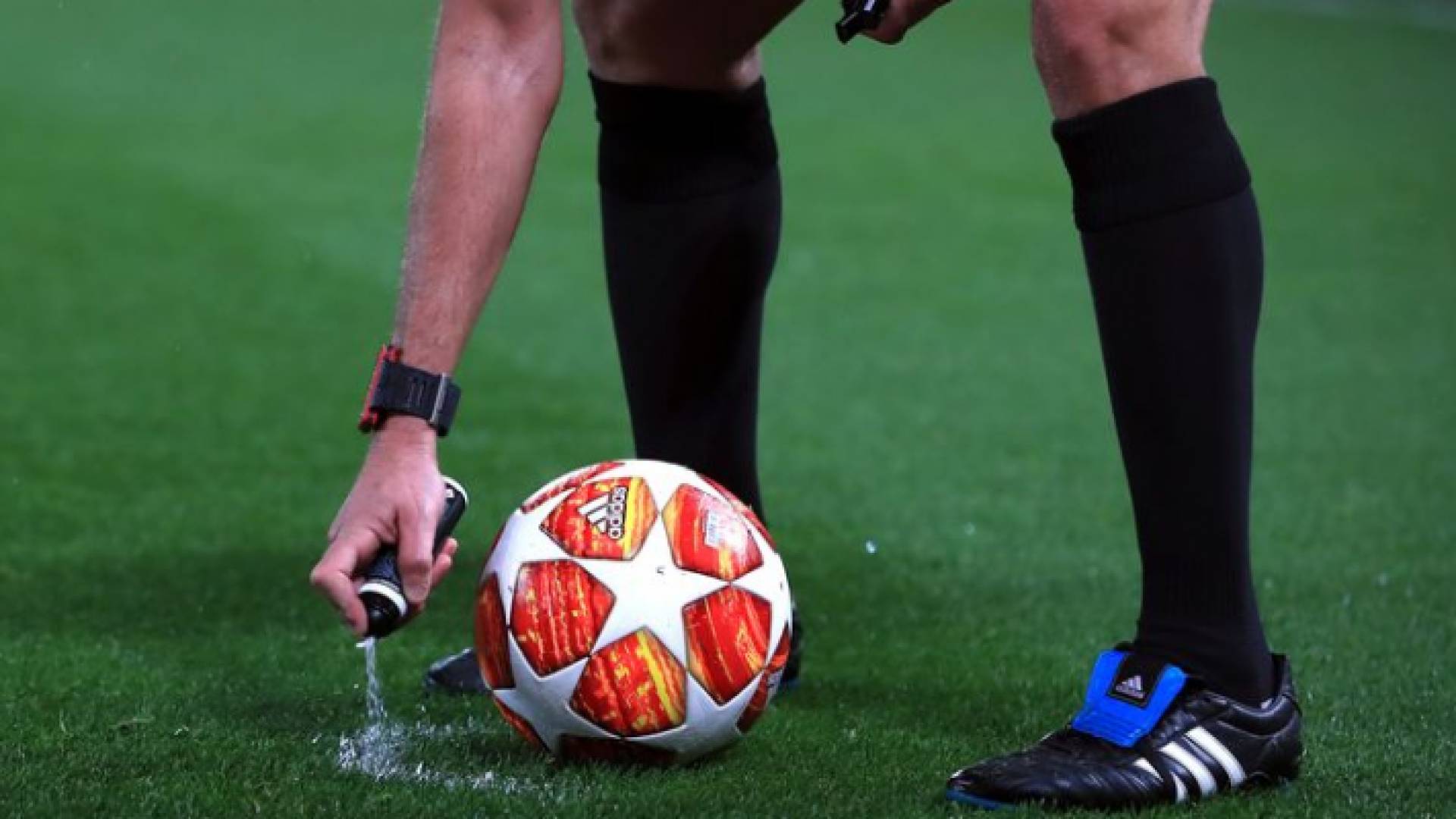 حكم يحمل كرة قدم