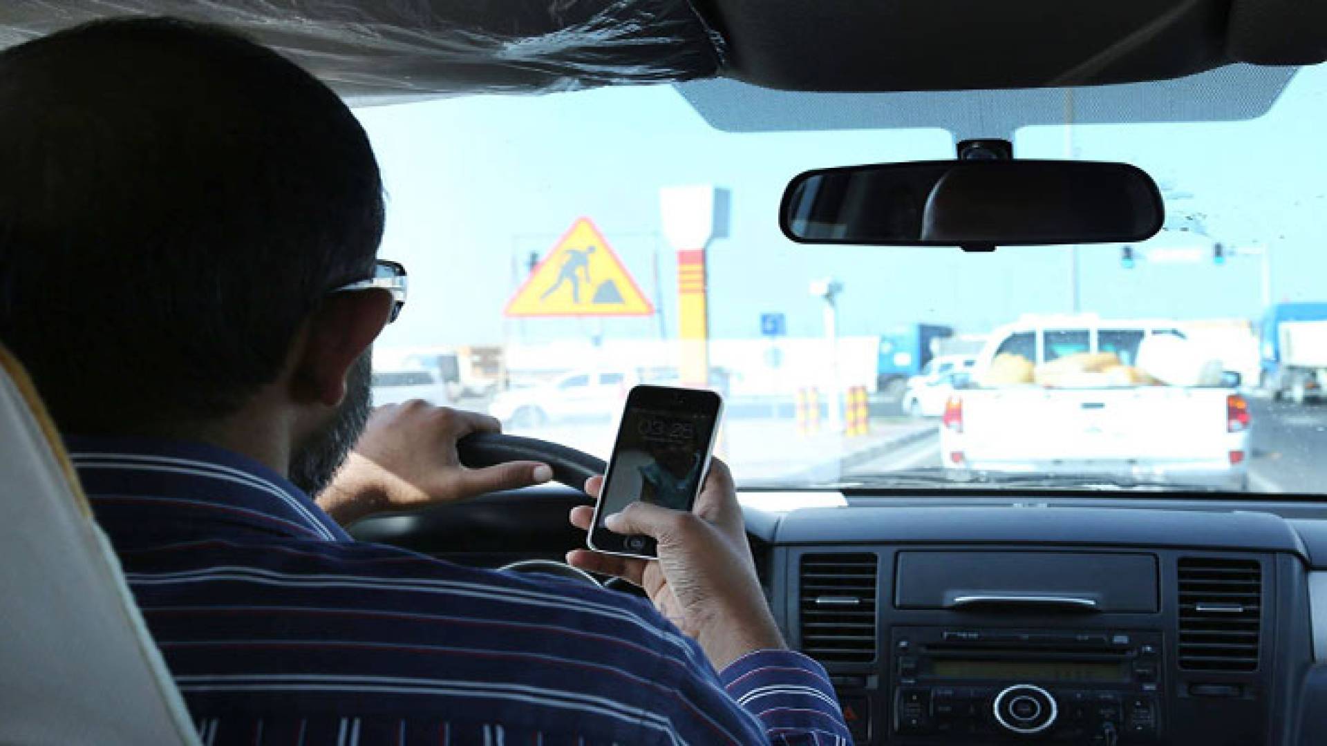 سائق يستخدم الهاتف أثناء القيادة