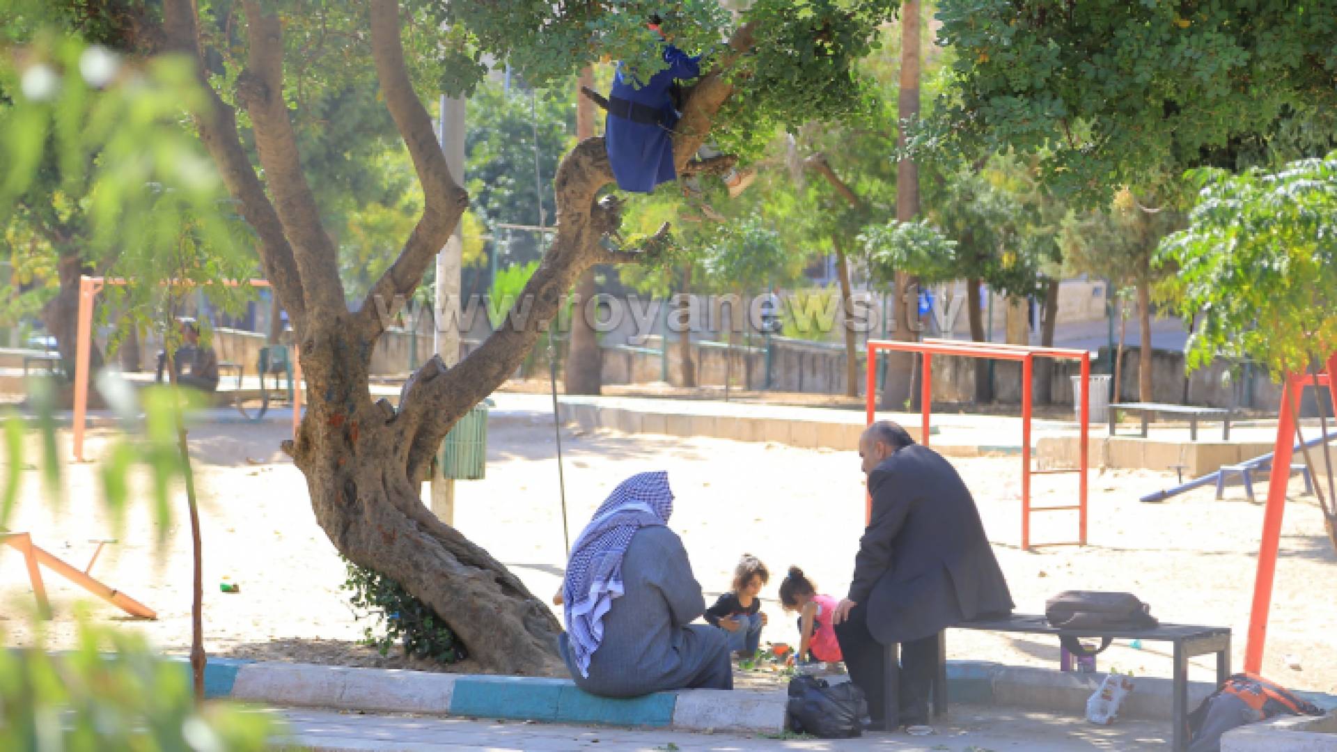 رجلان وأطفال في إحدى حدائق العاصمة عمان