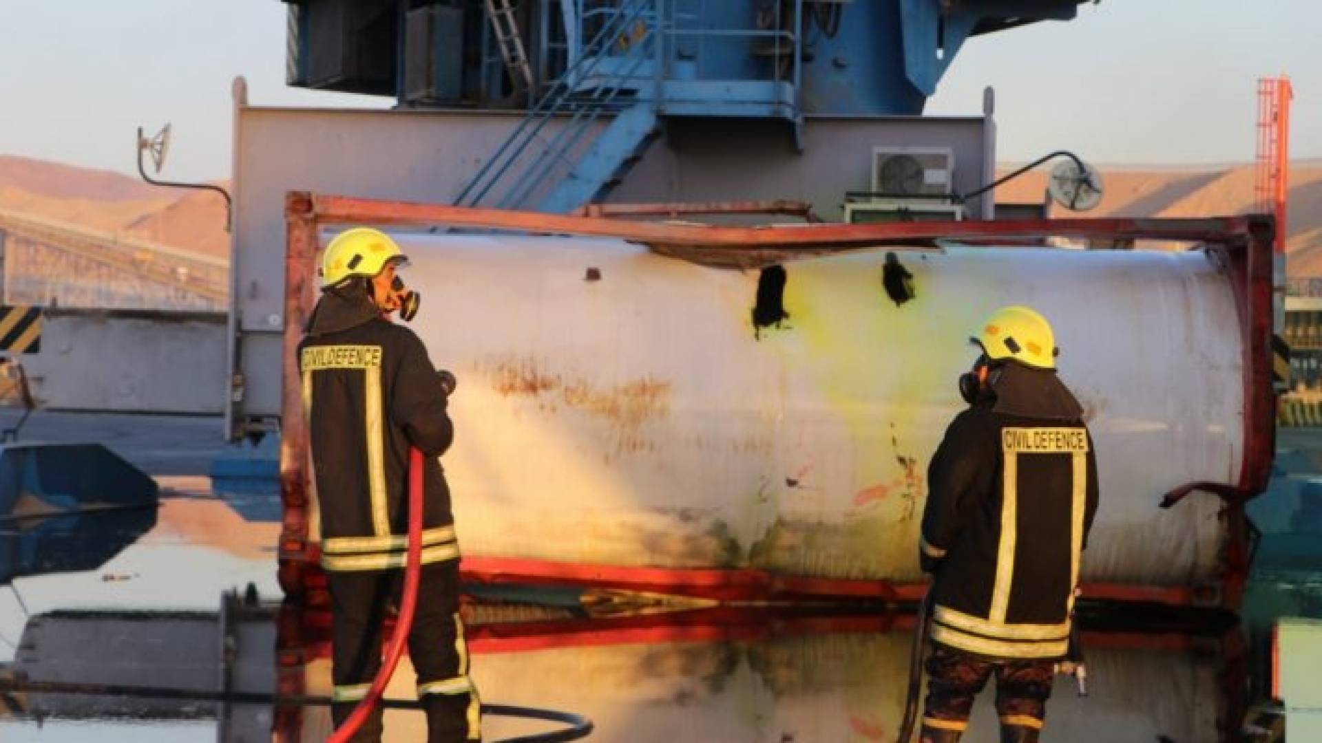 صورة لرجال الدفاع المدني إلى جانب الخزان الذي تسرب منه غاز الكلور في مدينة العقبة