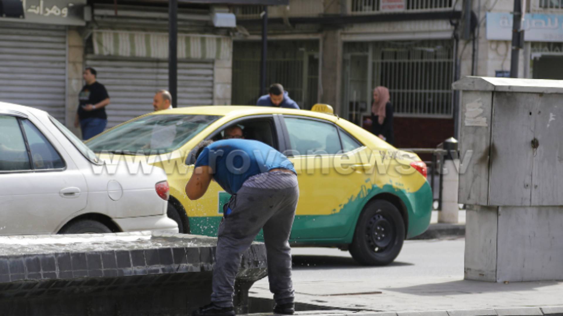 شخص يبلل رأسه بالماء في وسط البلد في العاصمة عمان