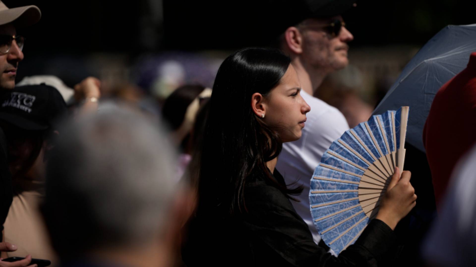 سيدة تحمل مروحة يدوية للتخفيف من شدة حرارة الطقس في فرنسا