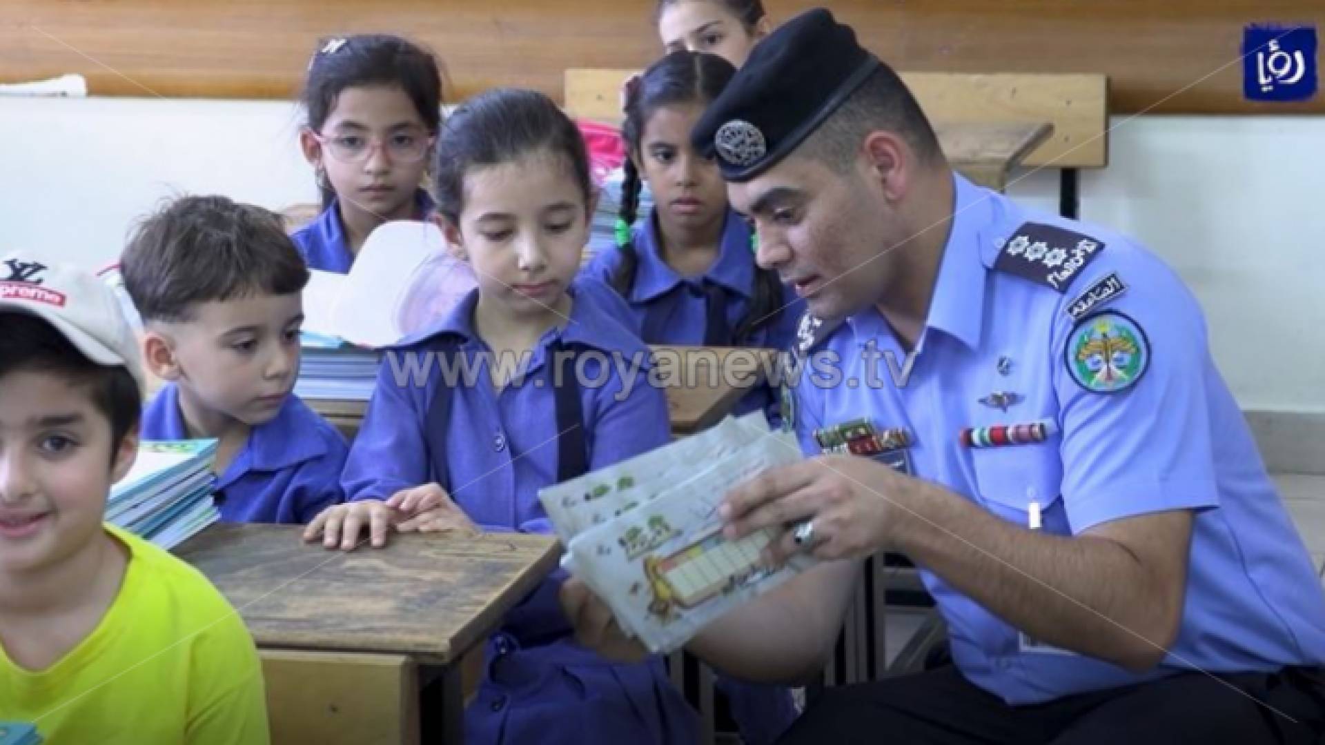 رجل أمن يتحدث إلى طالبات مع بالتزامن مع بداية العام الدراسي