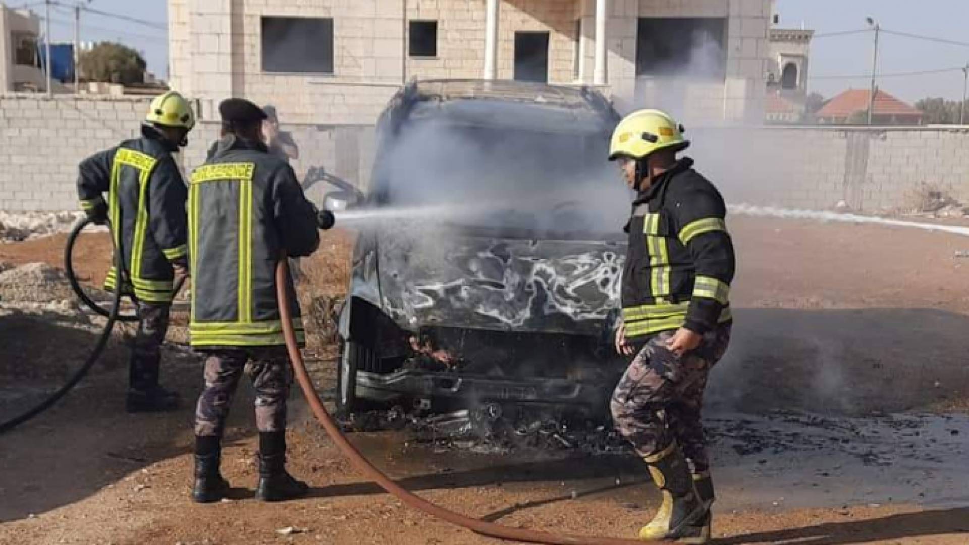 كوادر الدفاع المدني أثناء إخماد حريق المركبة