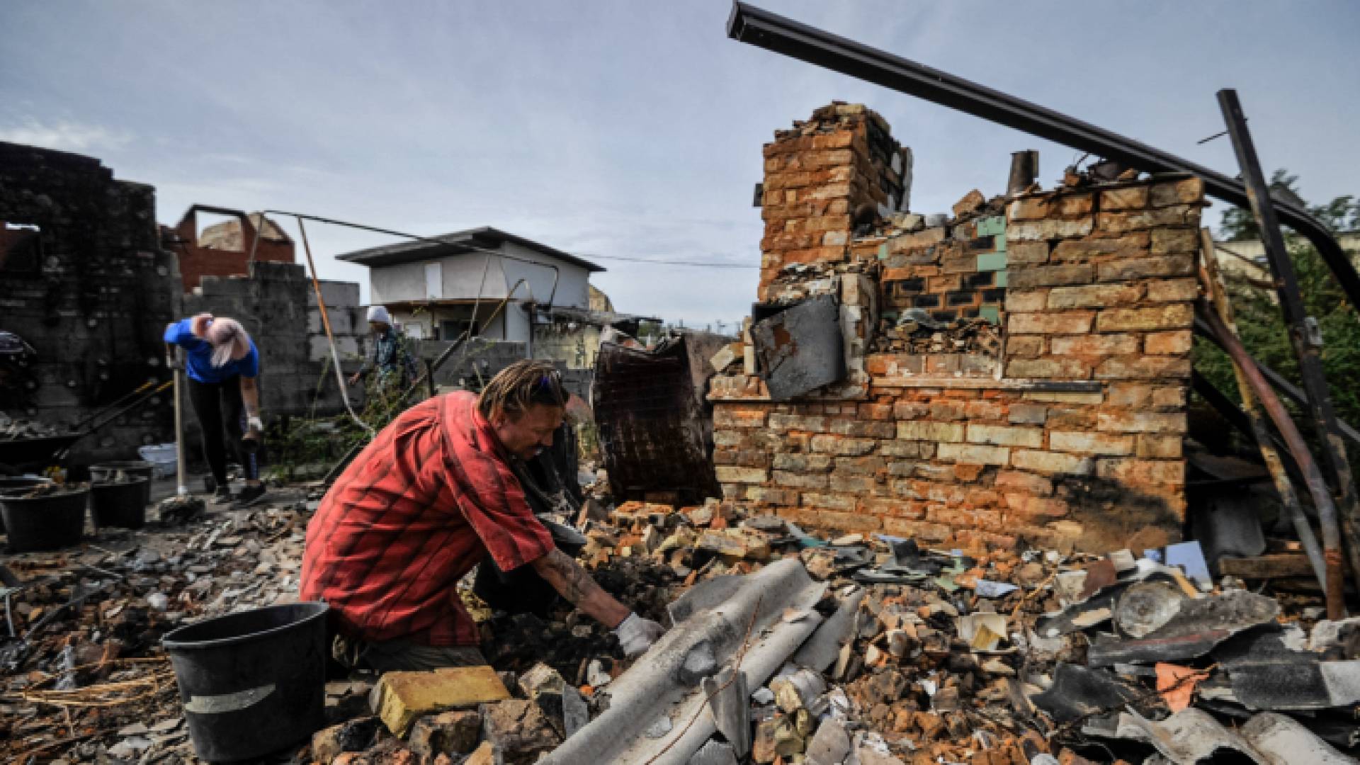 متطوعون يزيلون أنقاض منزل مدمر نتيجة قصف قرية موشون بمنطقة كييف