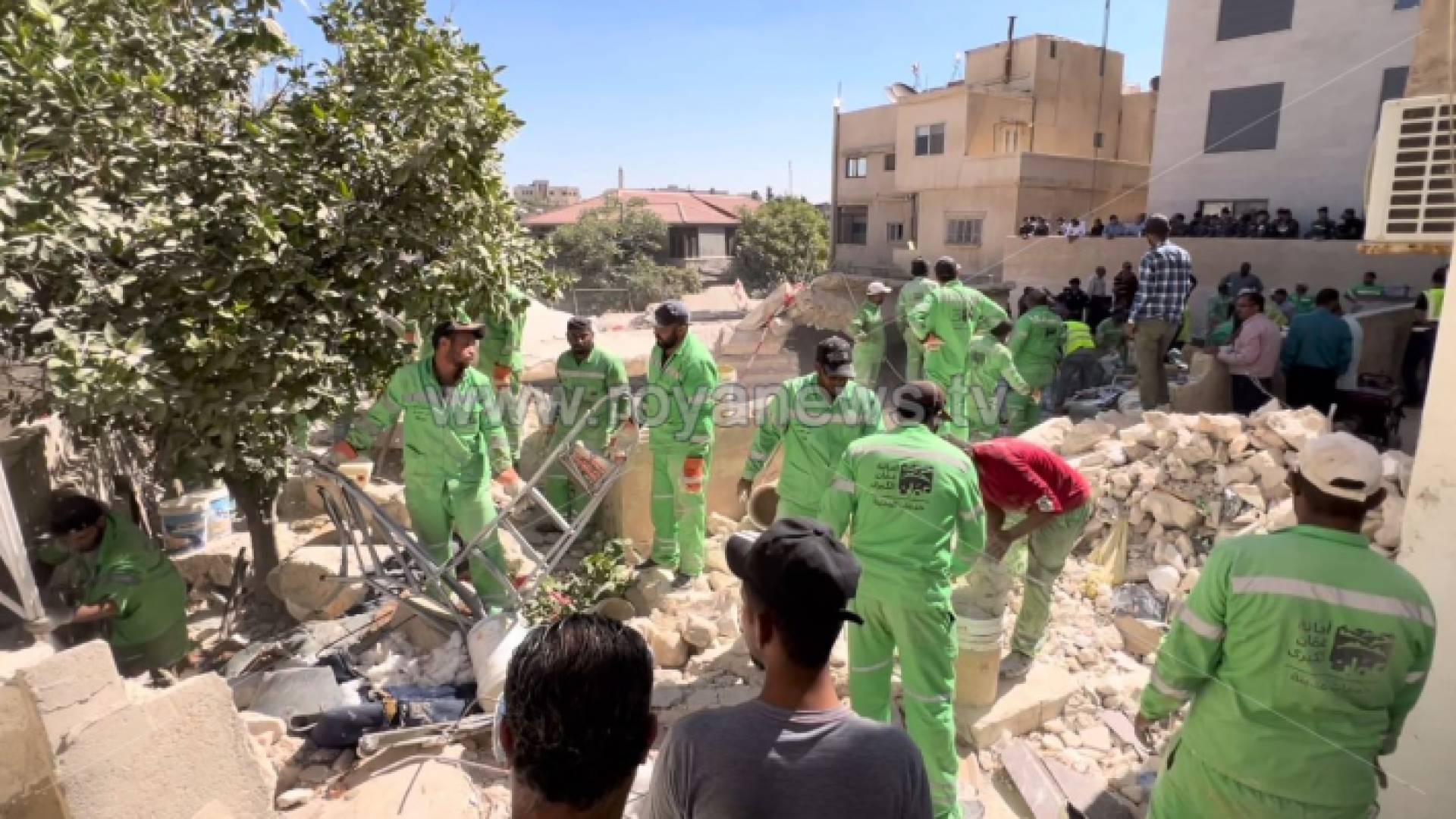 كوادر أمانة عمان أثناء إزالتهم للركام إلى جانب كوادر الدفاع المدني