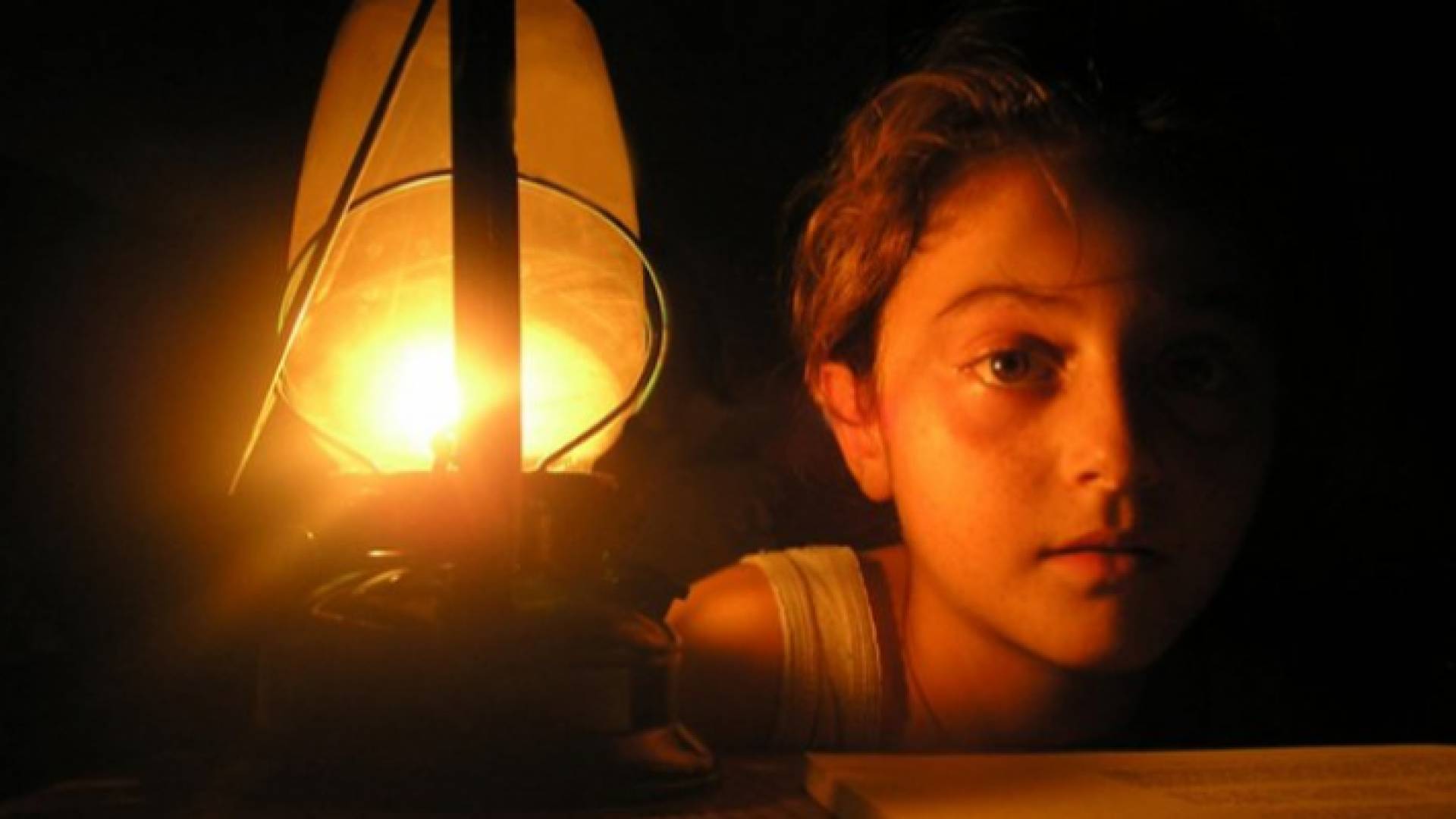 صورة توضيحية لطفلة تجلس على ضوء قنديل