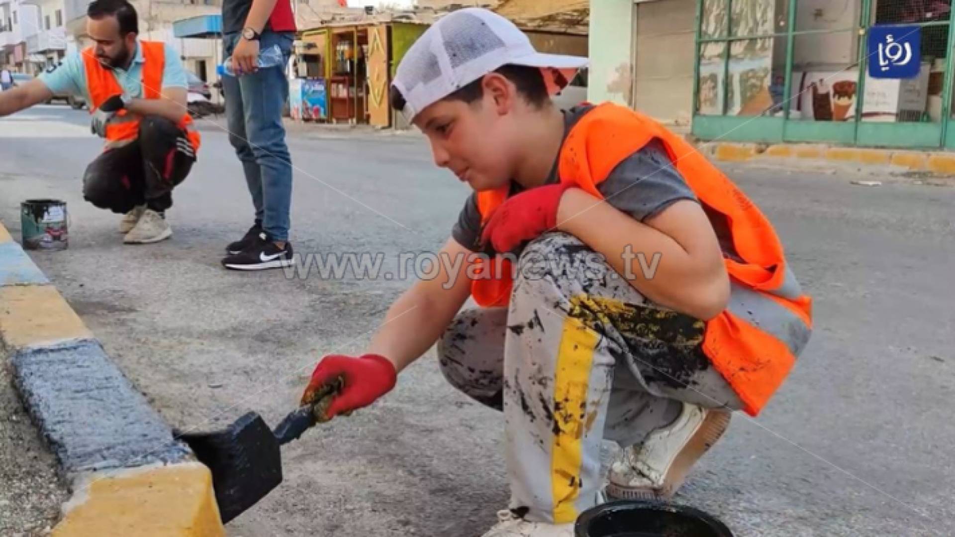 فتى يدهن الجزيرة الوسطية في أحد شوارع بلدة الشجرة ضمن مبادرة "بلدتي أجمل"