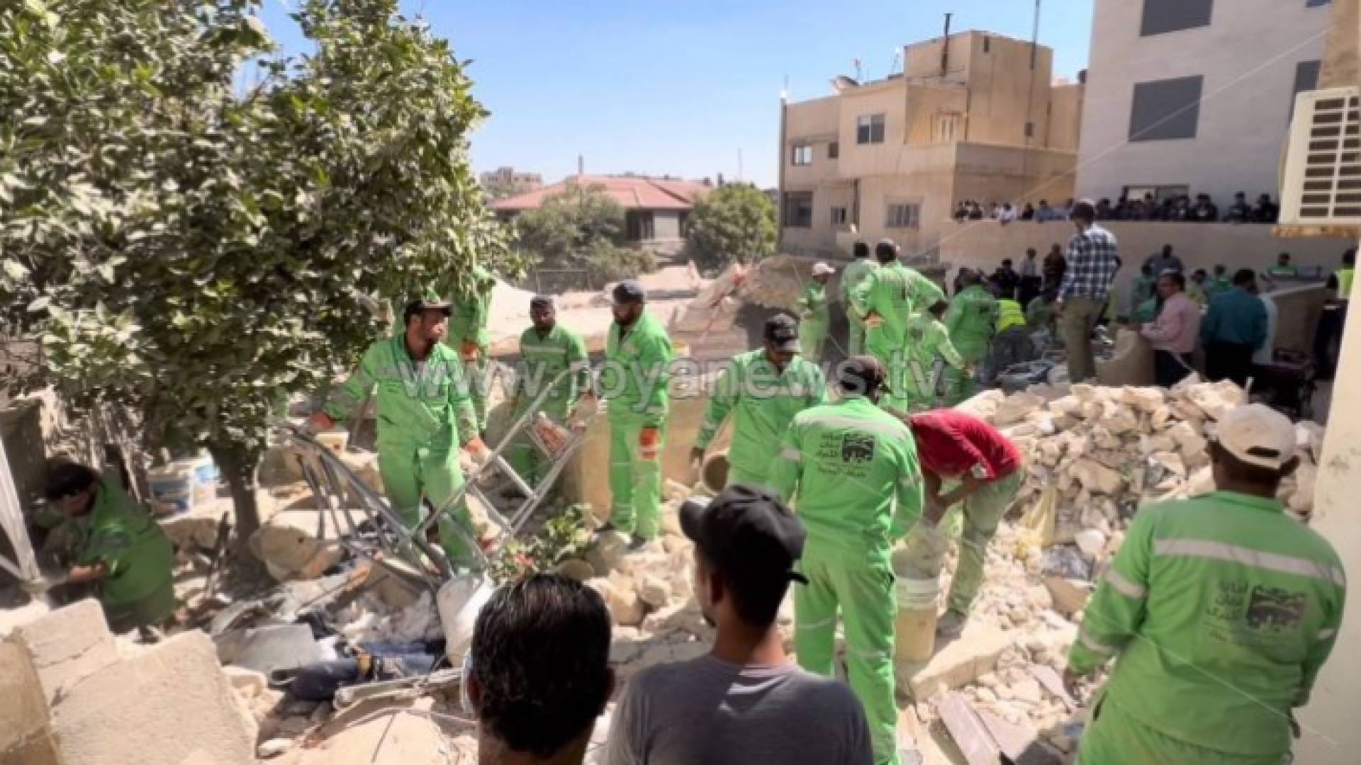 كوادر أمانة عمان أثناء إزالتهم لركام بناية اللويبدة