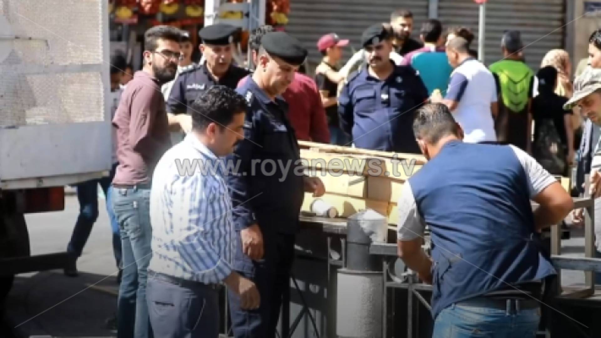 رجال أمن أثناء إزالتهم إحدى البسطات العشوائية في وسط البلد