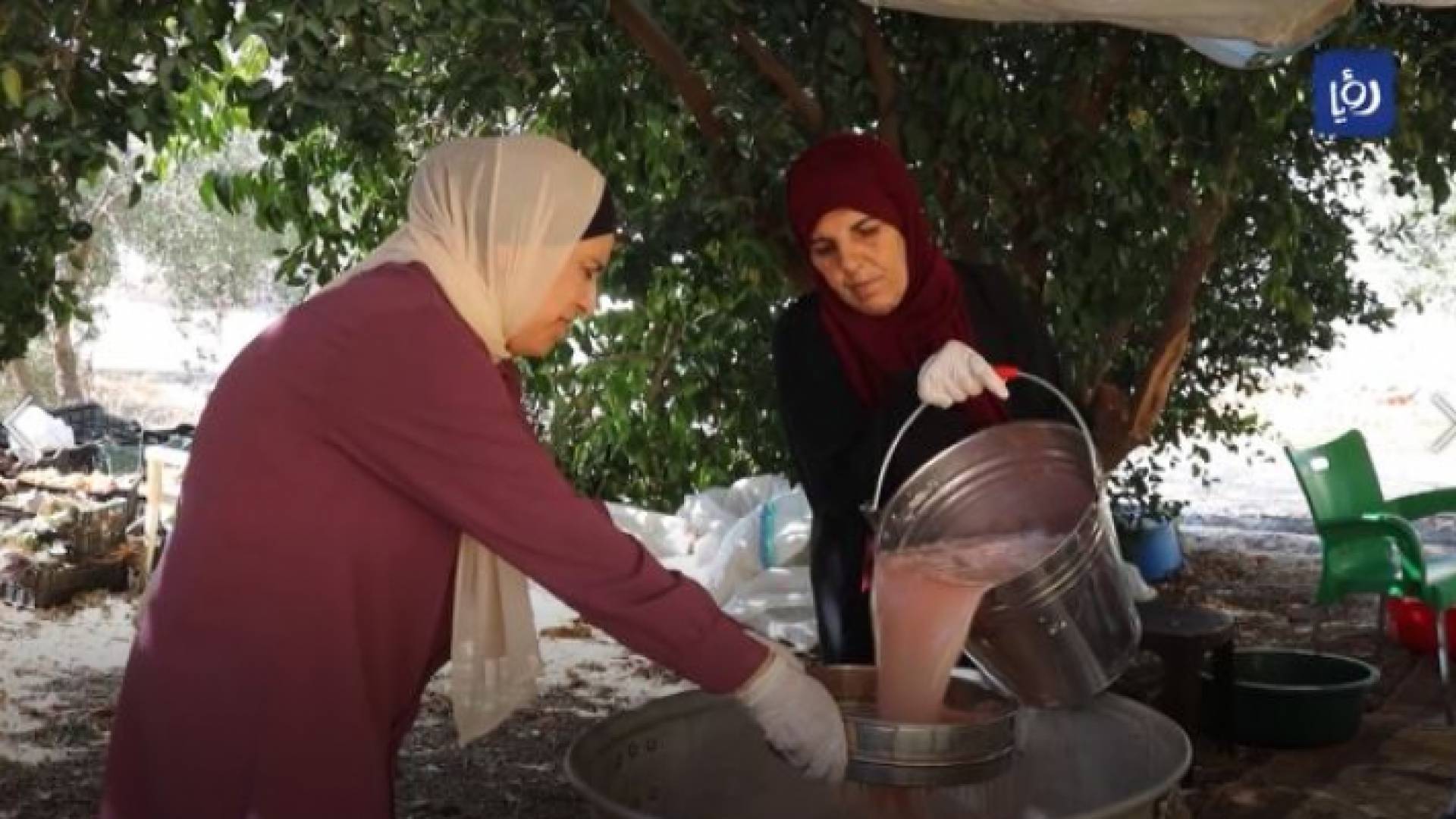 سيدتان تقومان بتصفية ثمار الرمان من قشوره