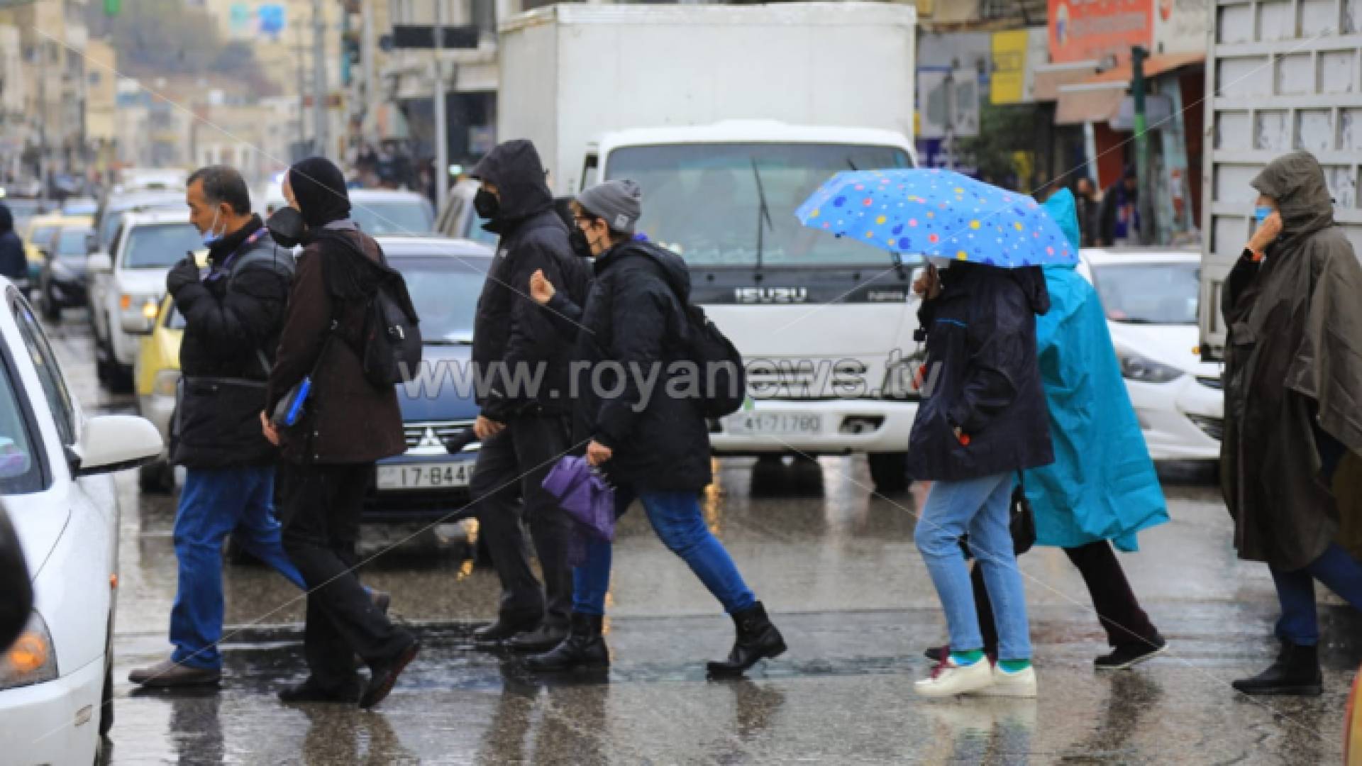 أشخاص يسيرون تحت المطر في وسط البلد بعمان - ارشيفية