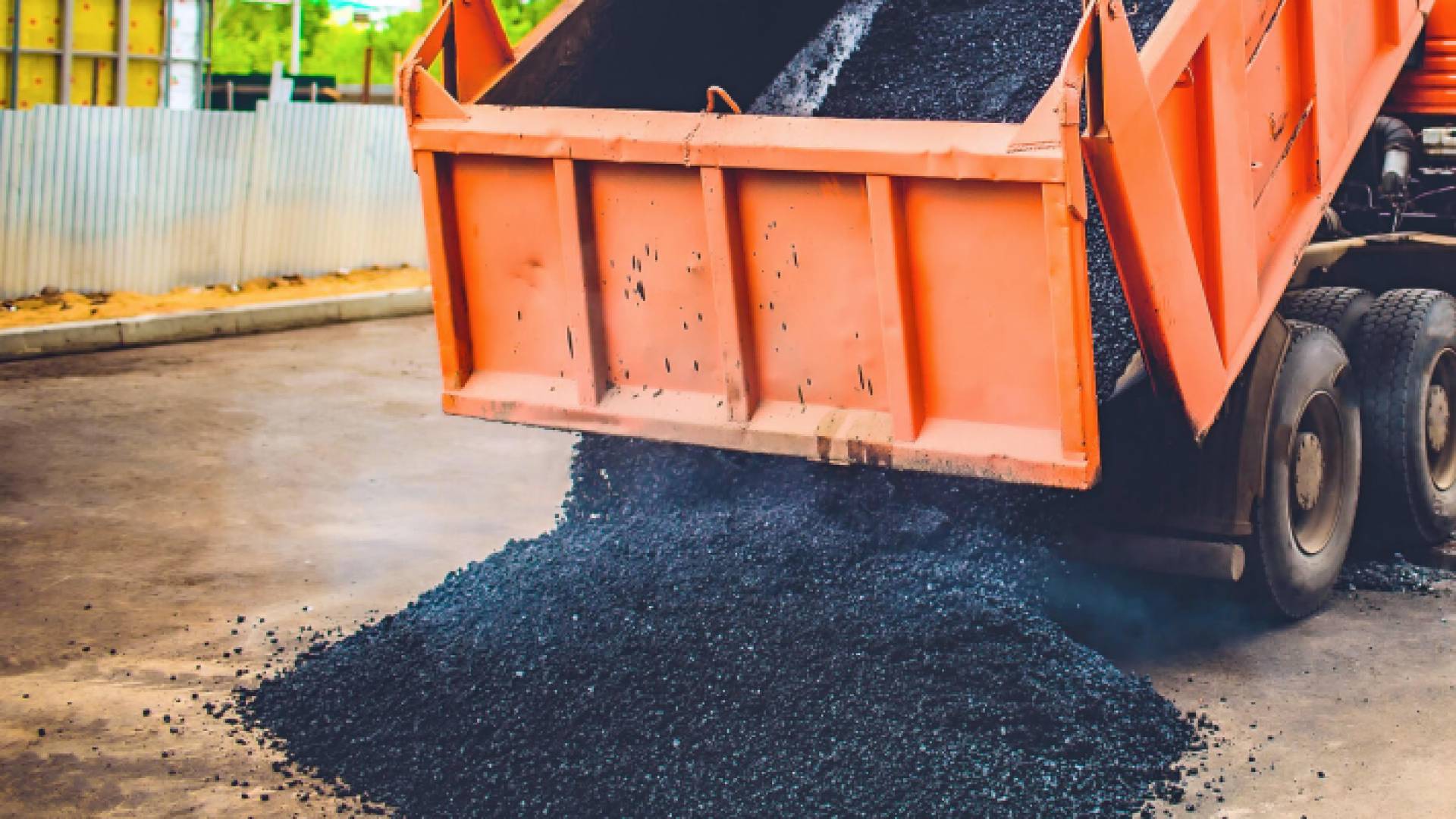 مركبة شحن تفرغ حمولتها من الأسفلت