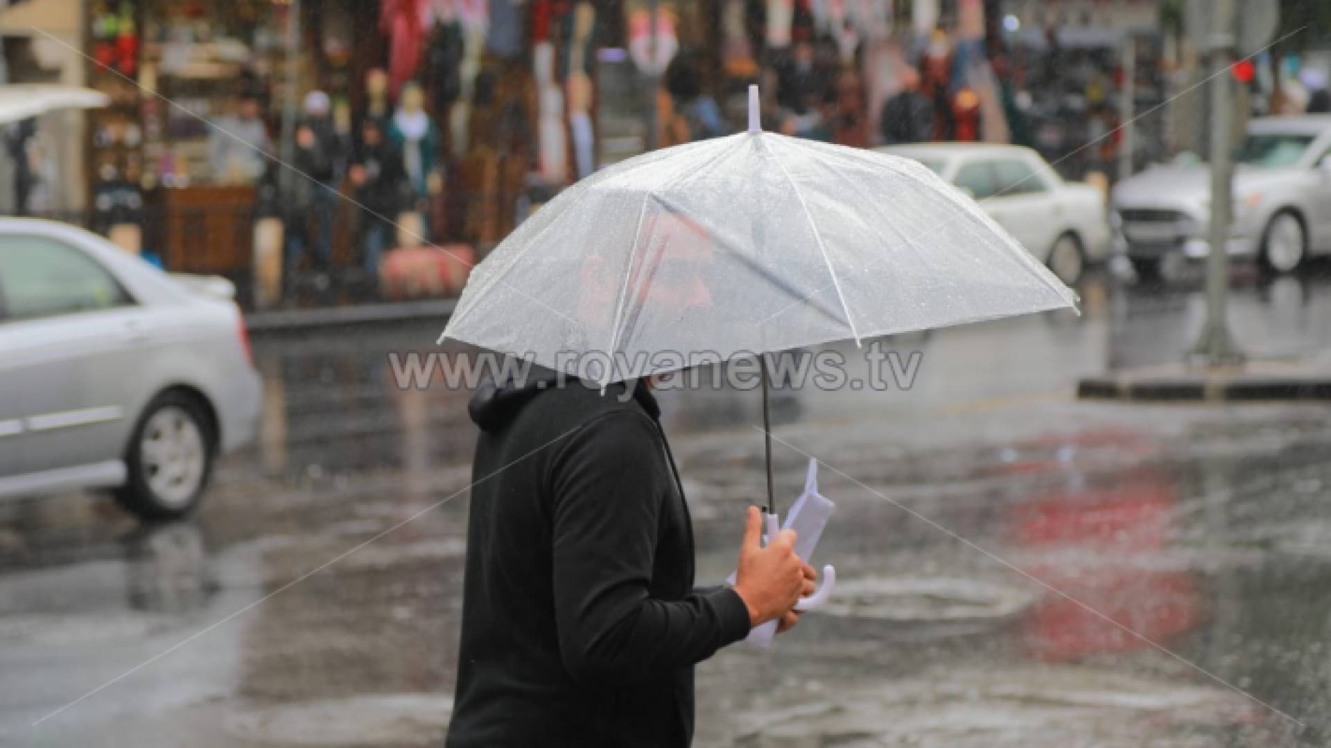 شخص يحمل مظلة في أحد شوارع العاصمة عمان