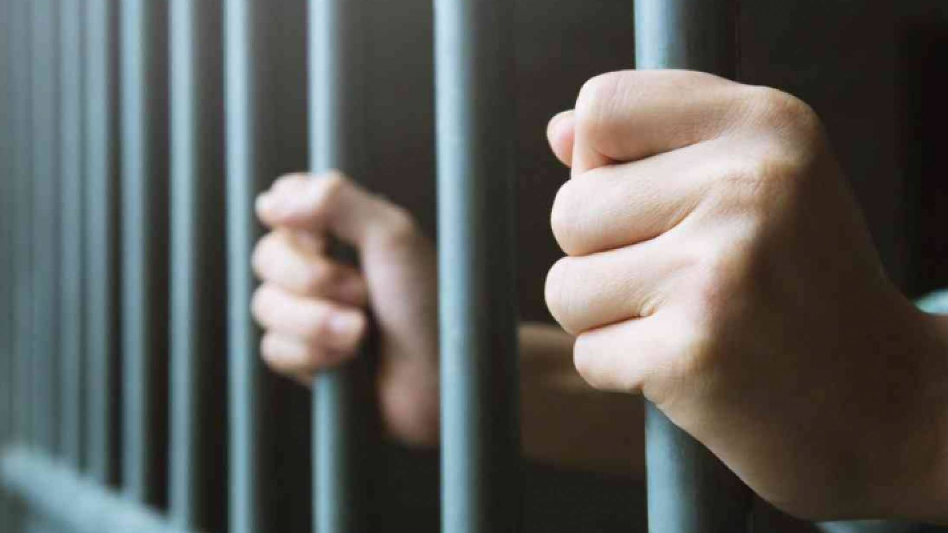 شخص يقف خلف القضبان