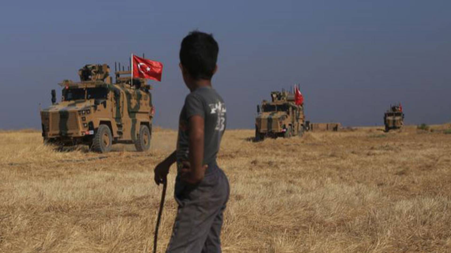 طفل يقف ينظر إلى القوات التركية
