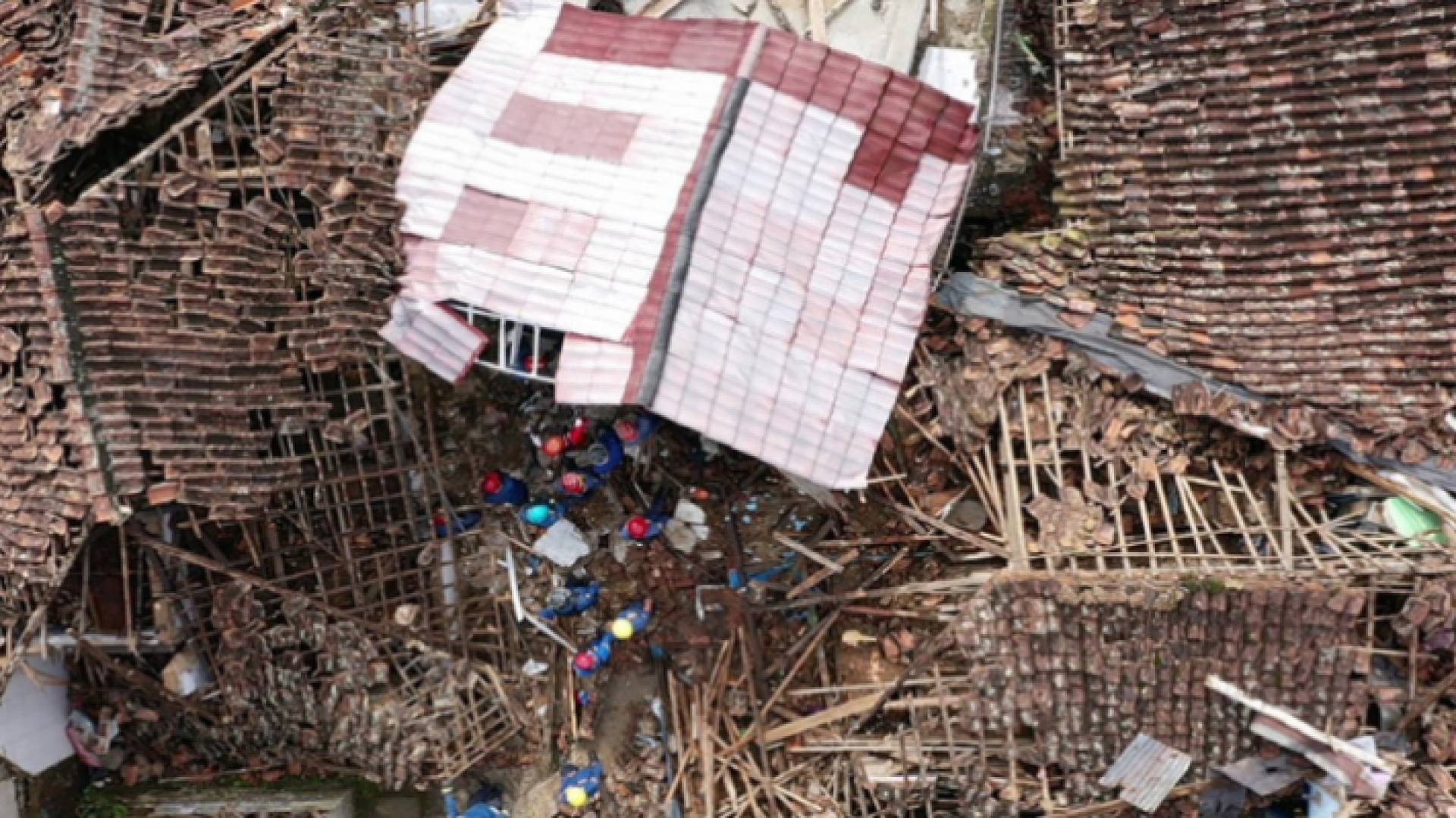 صورة جوية تظهر أفراد الإنقاذ يعملون على إنقاذ طفل من أنقاض منزل منهار في كوجينانج في جاوة الغربية بإندونيسيا