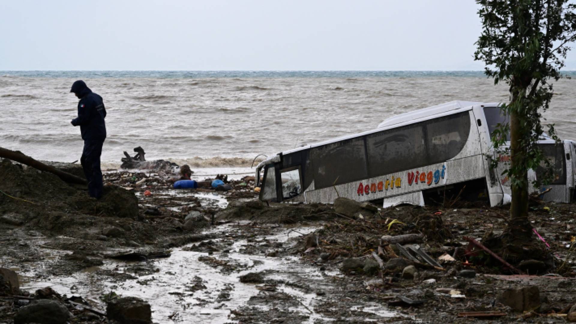 رجل يسير بجوار سيارات مدمرة