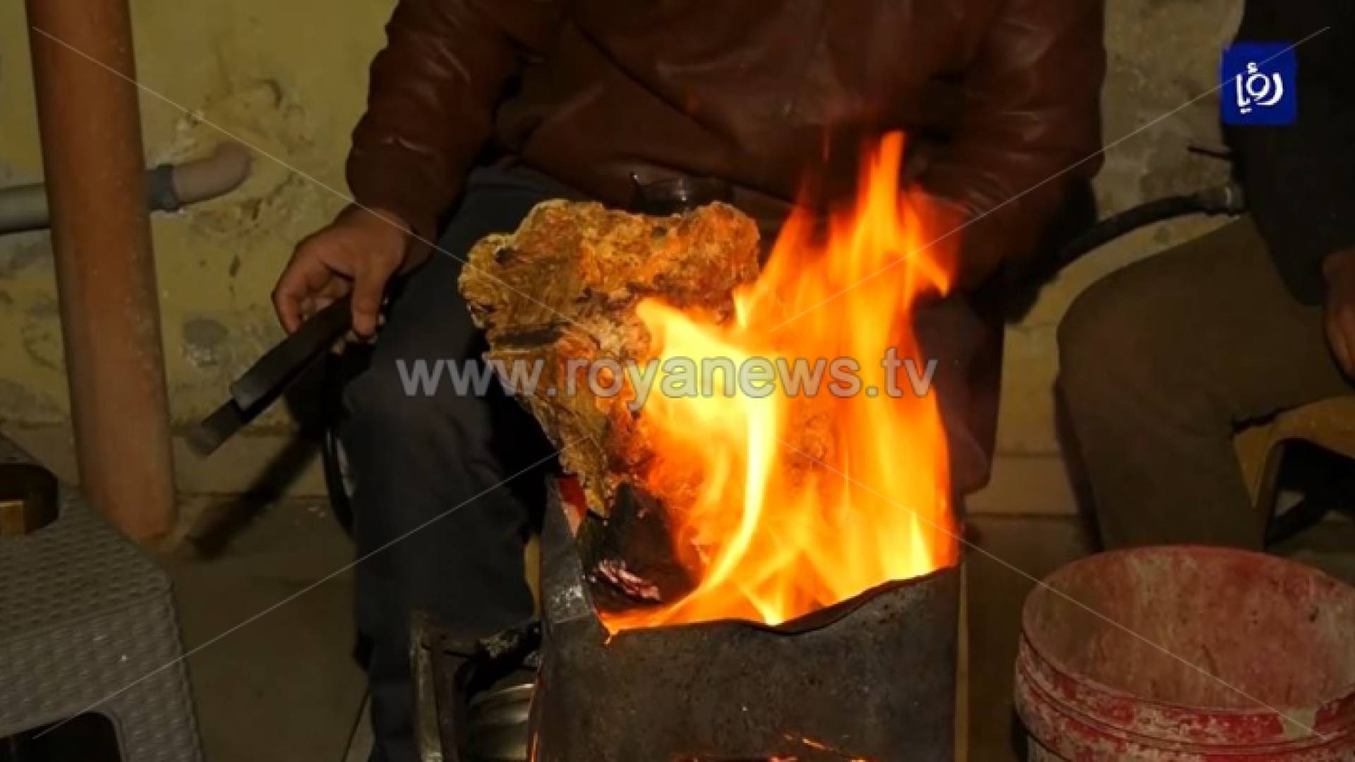 رجل يجلس أمام موقدة نار