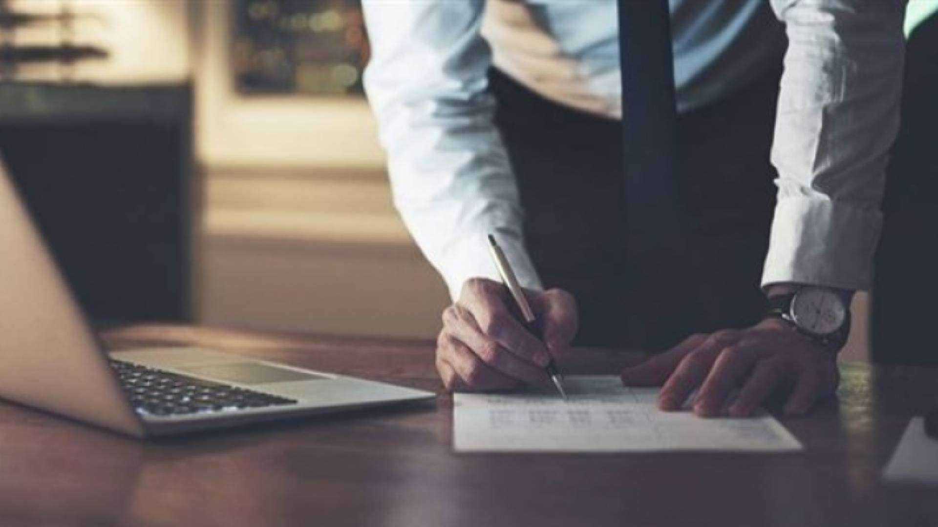 صورة تعبيرية لمدير يوقع إحدى المعاملات الورقية