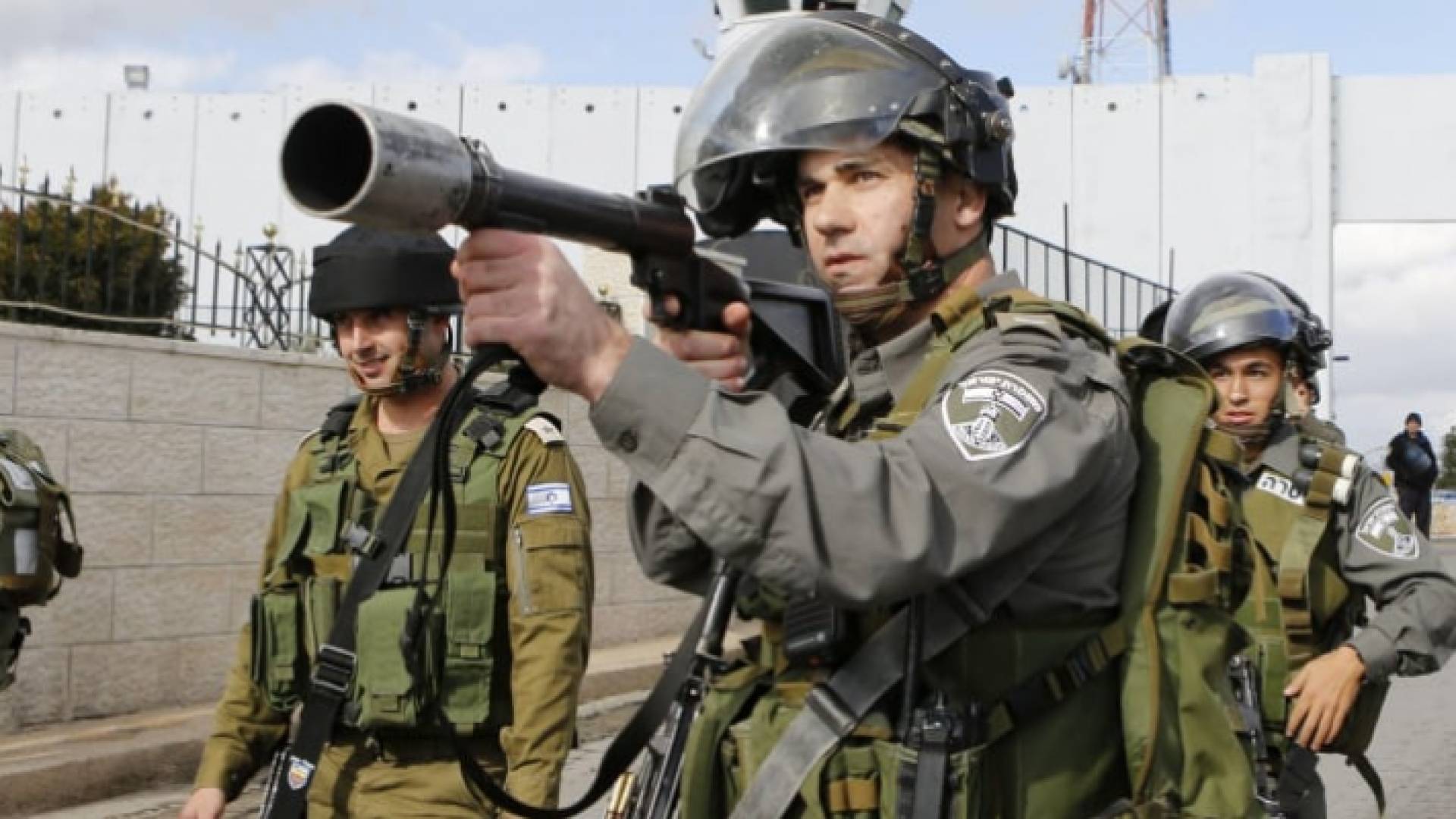 عنصر من جنود الاحتلال يصوب بندقيته نحو فلسطينين