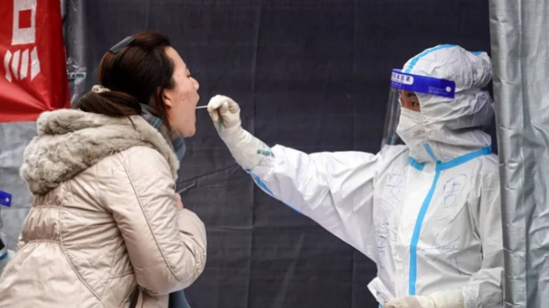 عامل في القطاع الصحي الصيني يأخذ عينة كورونا من فتاة