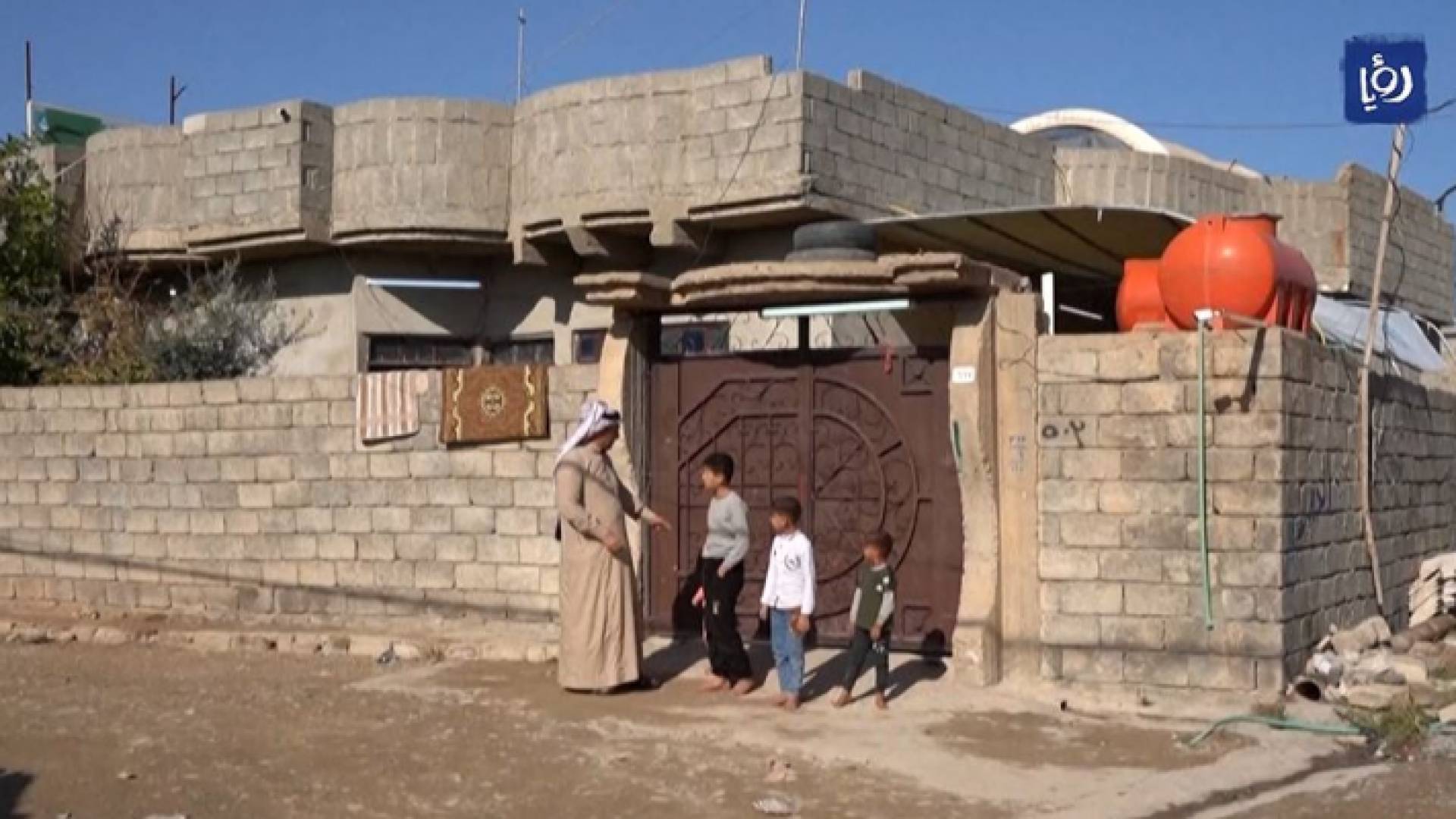 عراقي وأطفاله أمام منزلهم