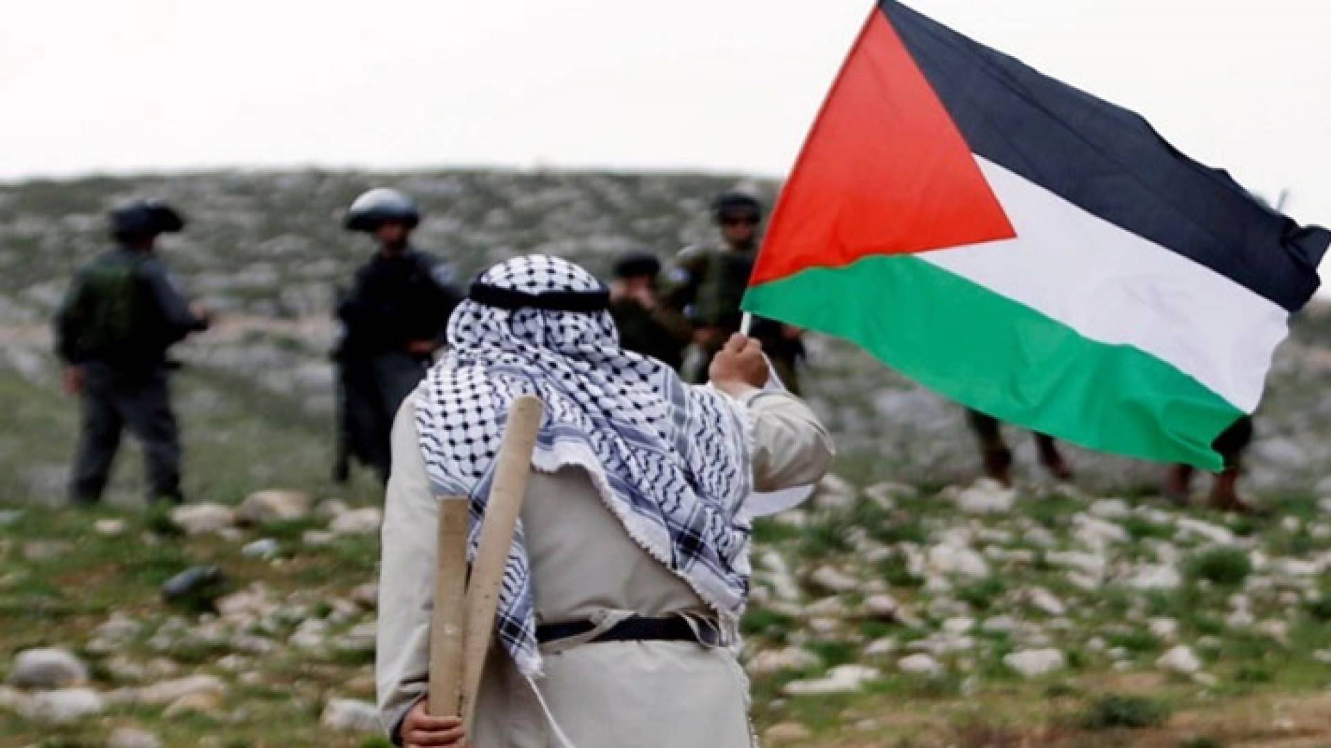 مسن فلسطيني يرفع علم بلاده في وجه جنود الاحتلال الإسرائيلي