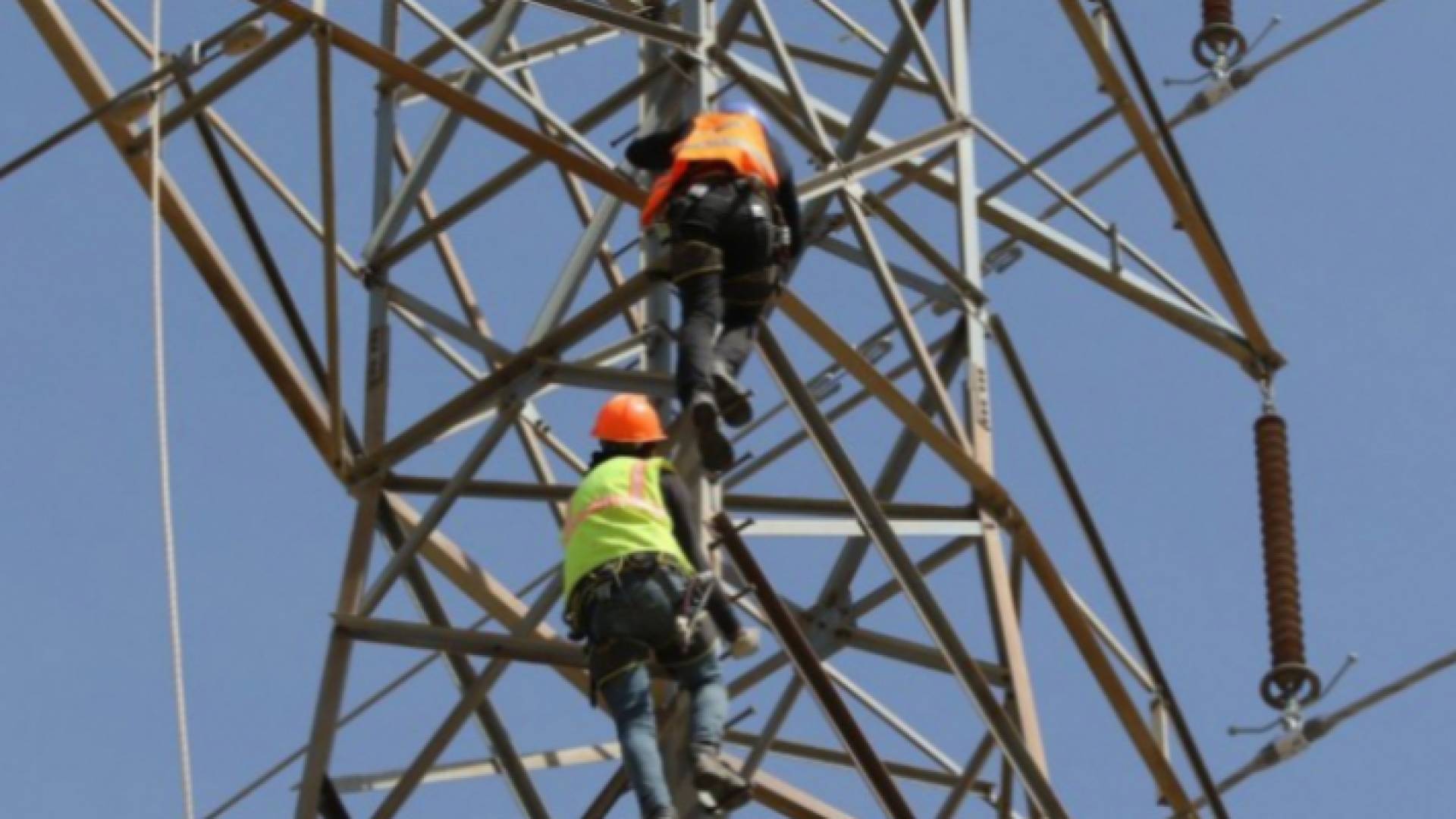 عاملان يجريان صيانة لخطوط الشبكة الكهربائية