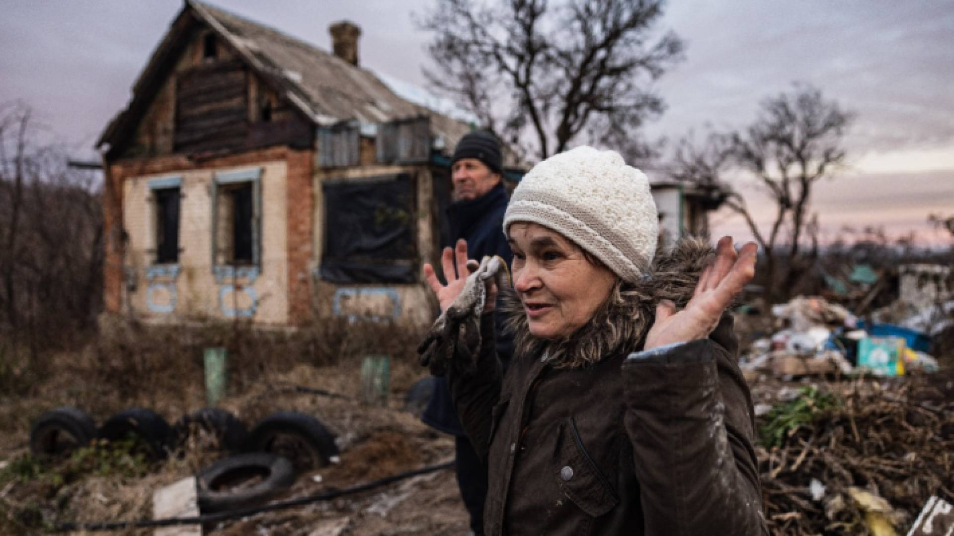 عائلة أوكرانية تقف أمام منزلها المدمر