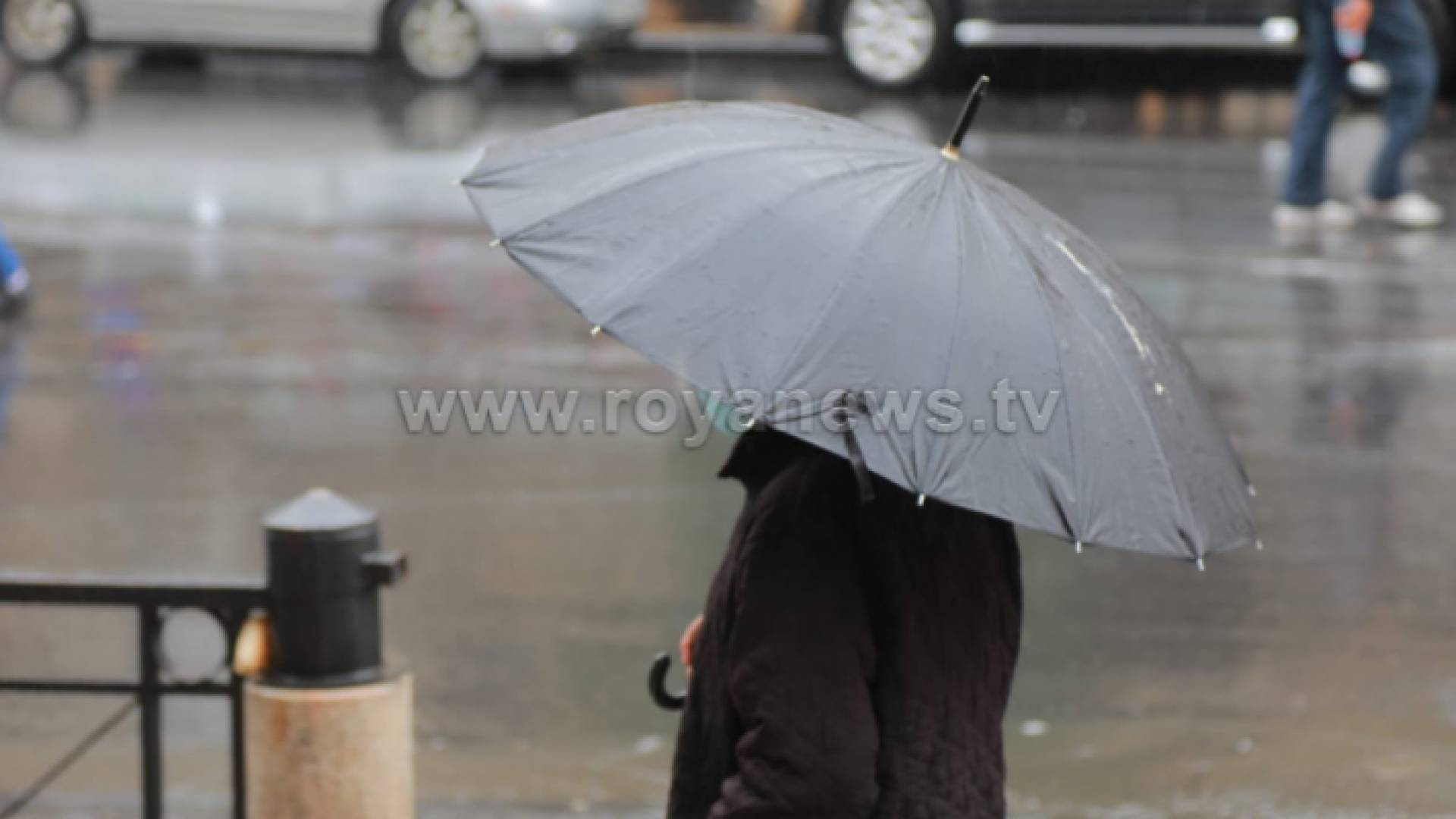 أردني يسير تحت مظلته في أحد شوارع العاصمة عمان