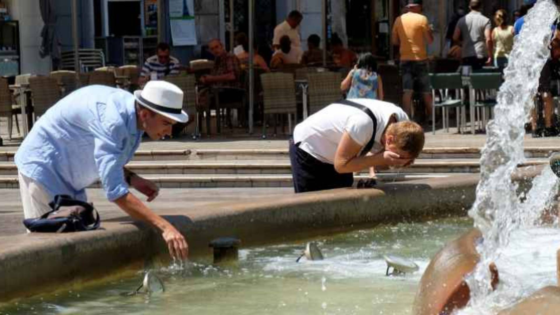 أشخاص يعرضون وجوههم للماء نتيجة لارتفاع درجات الحرارة في بريطانيا - أرشيفية