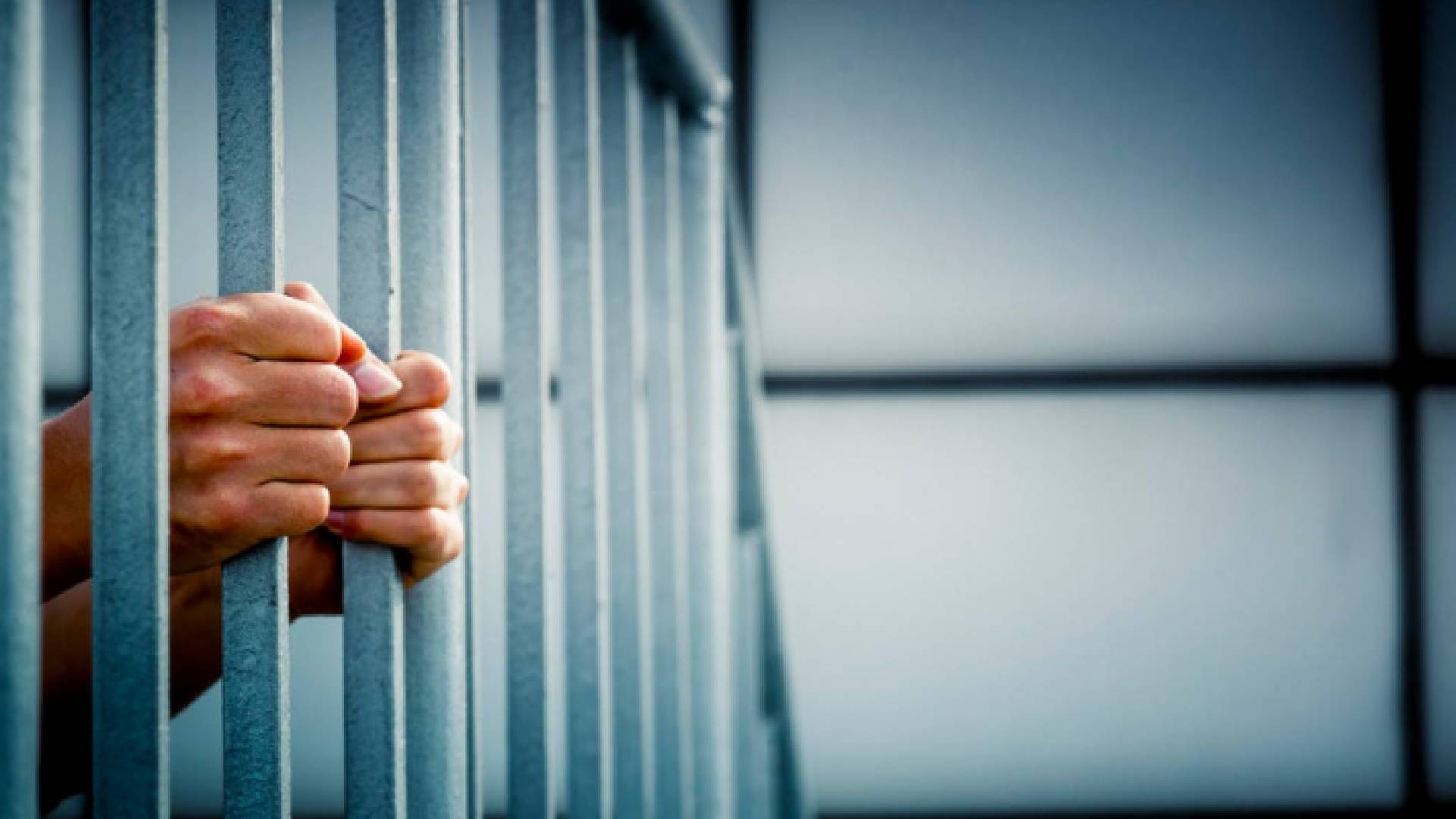 سجين يقف خلف القضبان - تعبيرية