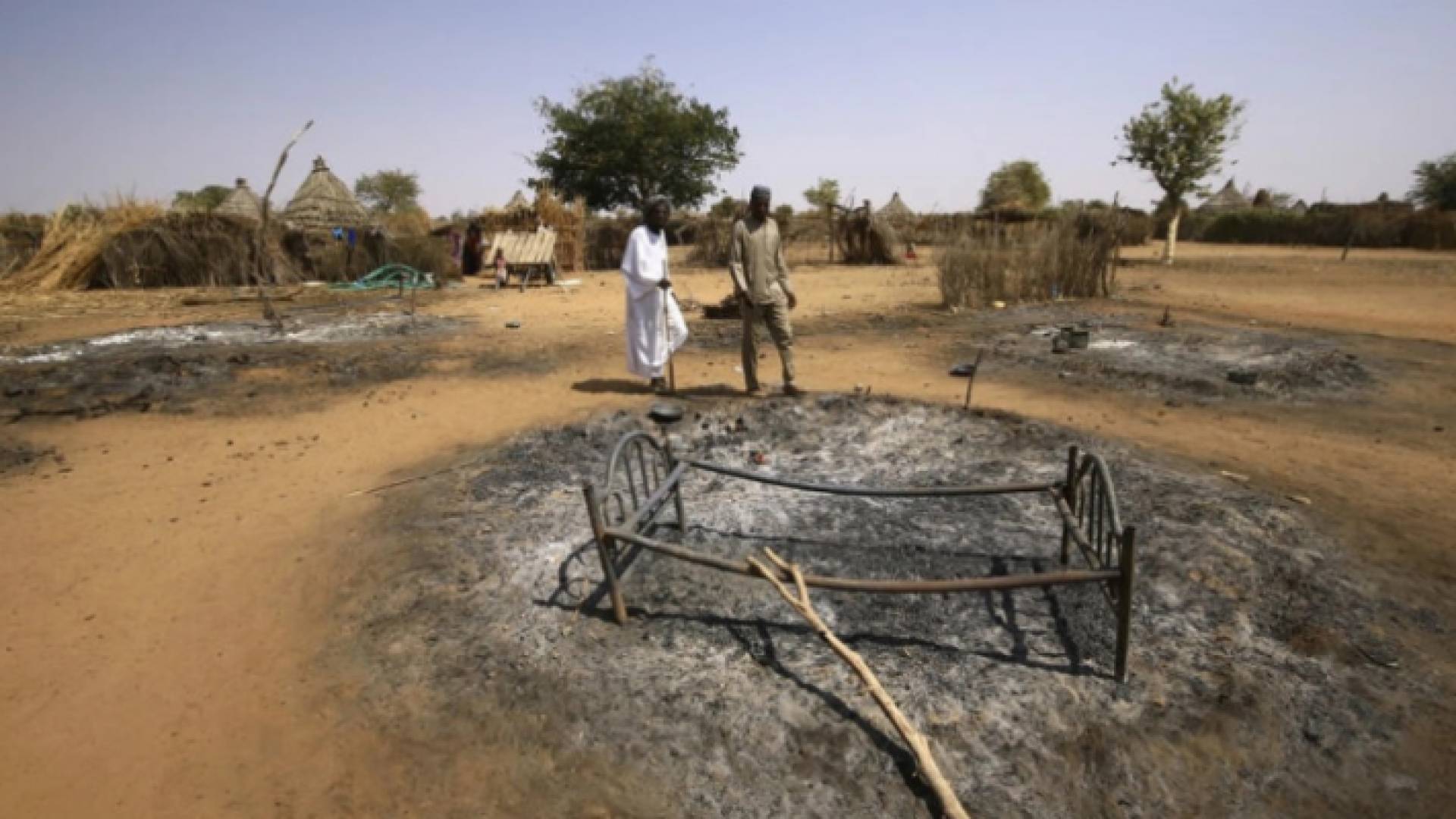 صورة أرشيفية لسودانيين يتفقدان أضرارا خلفتها أعمال عنف في جنوب دارفور