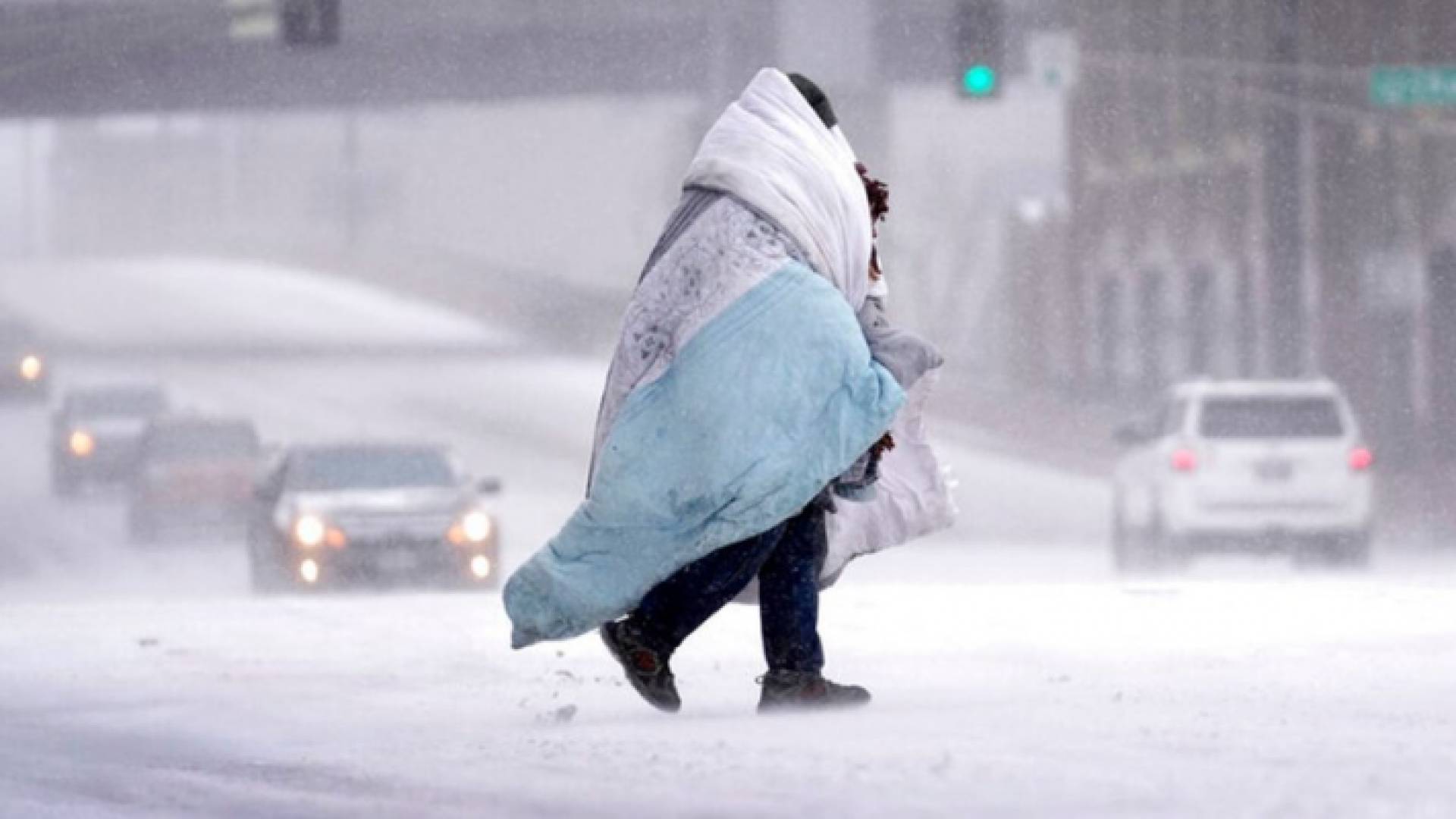 مواطن أمريكي يمشي في أحد الشوارع أثناء العاصفة الثلجية