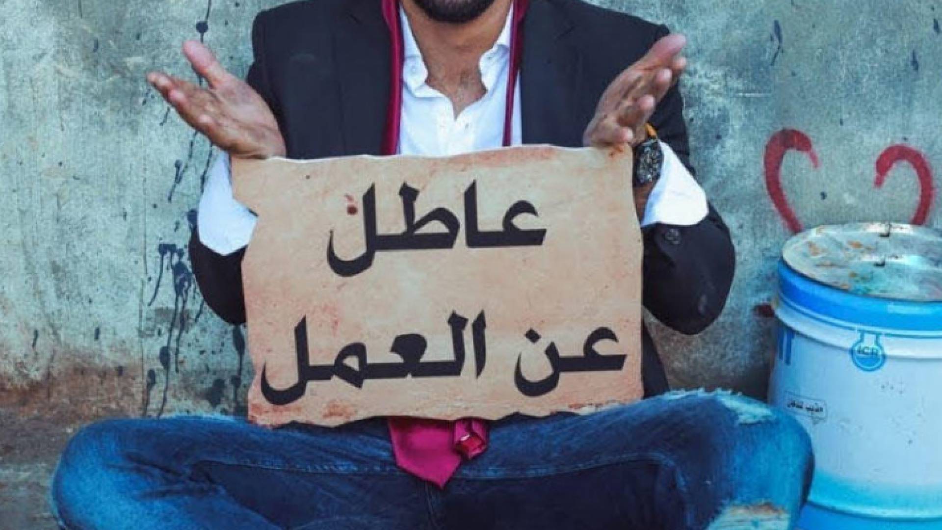 شخص يعمل يافطة "عاطل عن العمل"