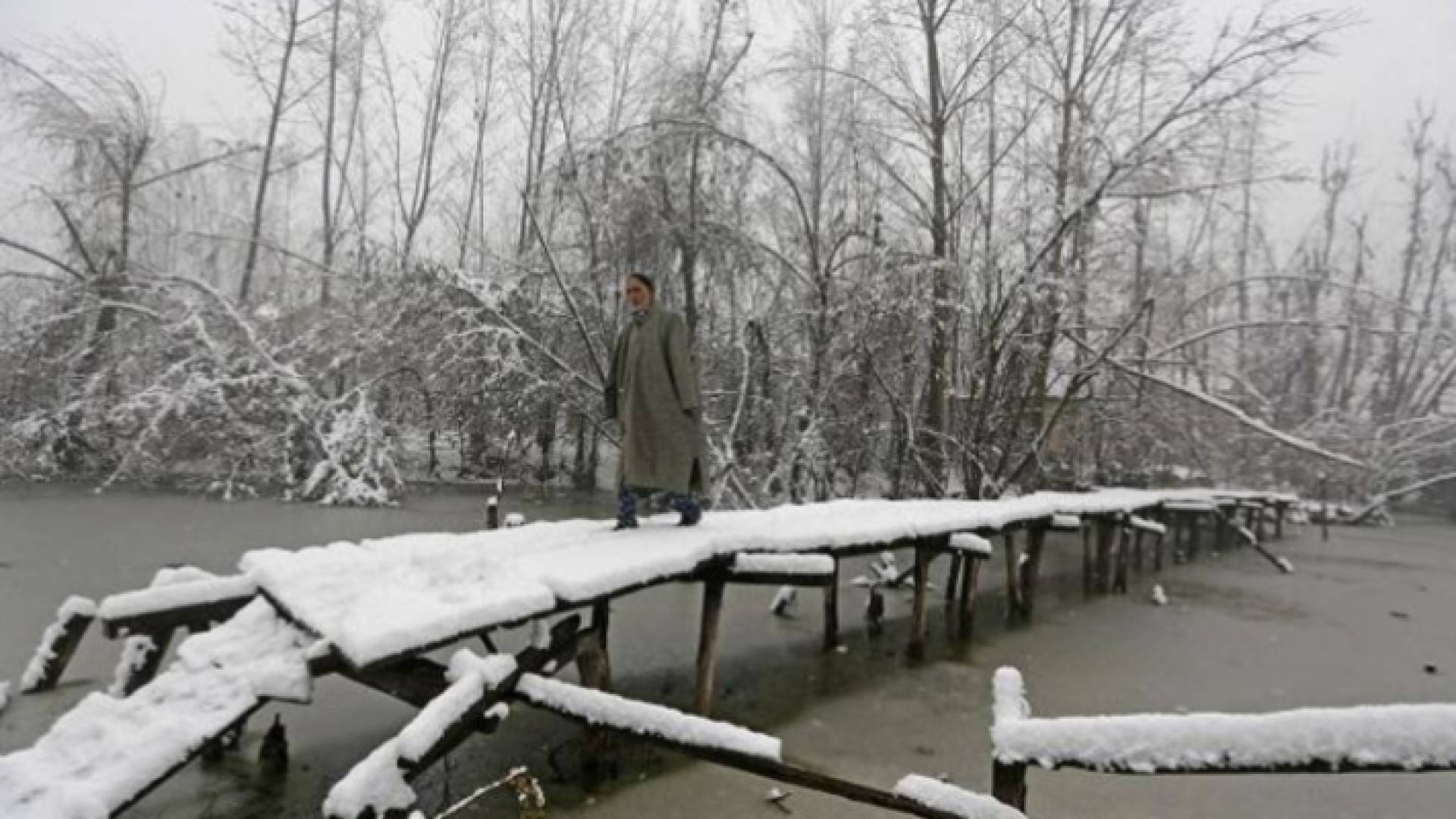 هندي يسير على جسر خشبي مغطى بالثلوج