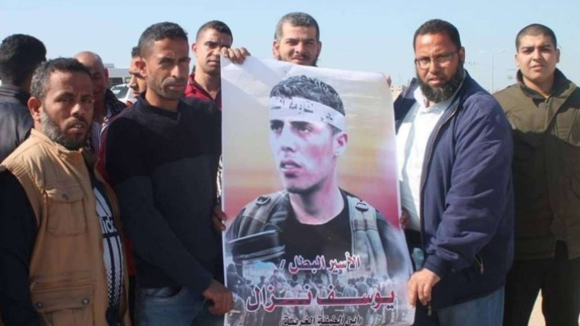 فلسطنينون يحملون صورة للأسير يوسف نزال