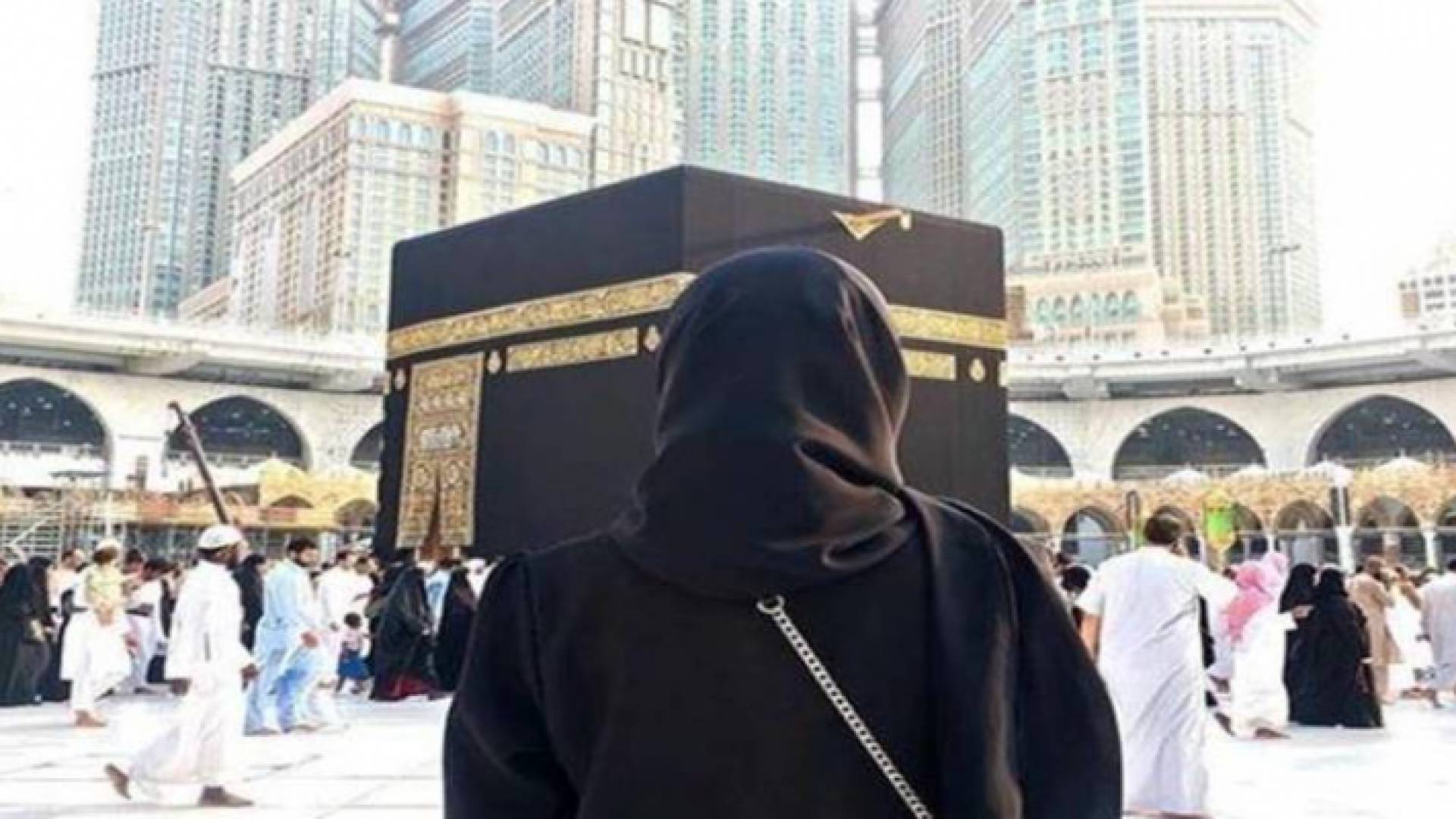 صورة تعبيرية لمعتمرة تقف أمام الكعبة المشرفة
