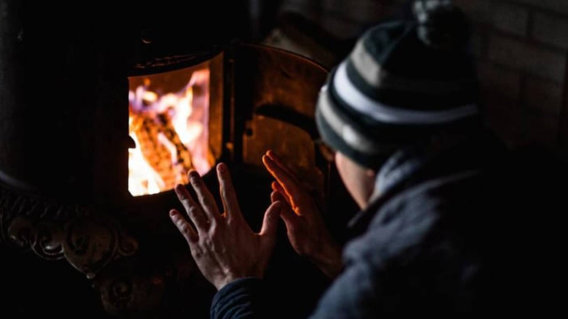 شخص يجلس أمام مدفأة - ارشيفية