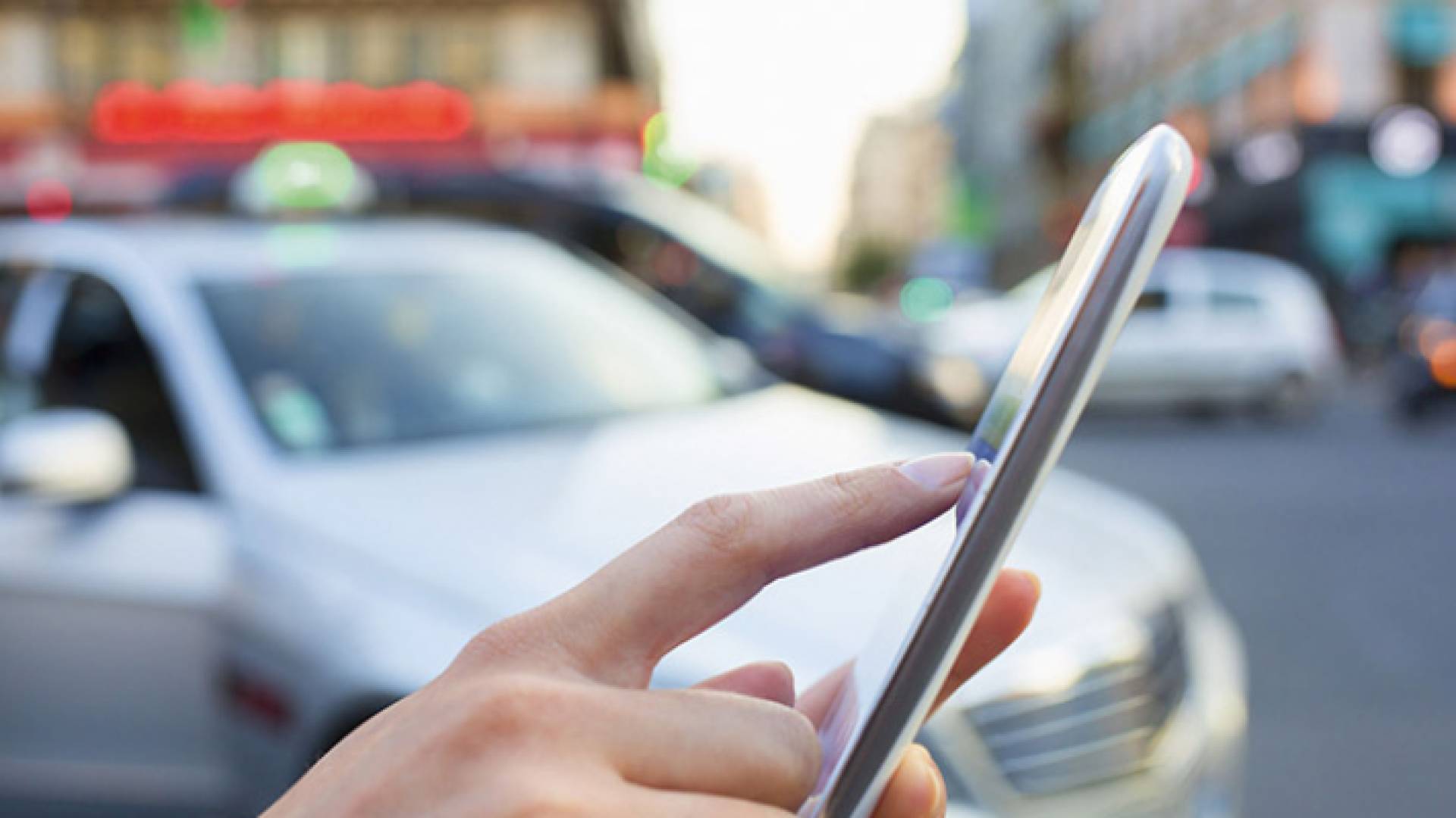 سيدة تطلب مركبة عبر تطبيقات النقل الذكية