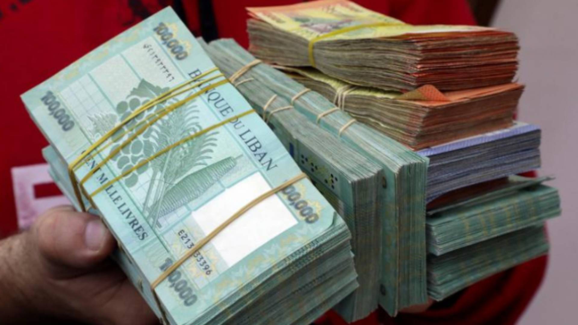 صراف يعرض أوراقا نقدية لعملة الليرة اللبنانية