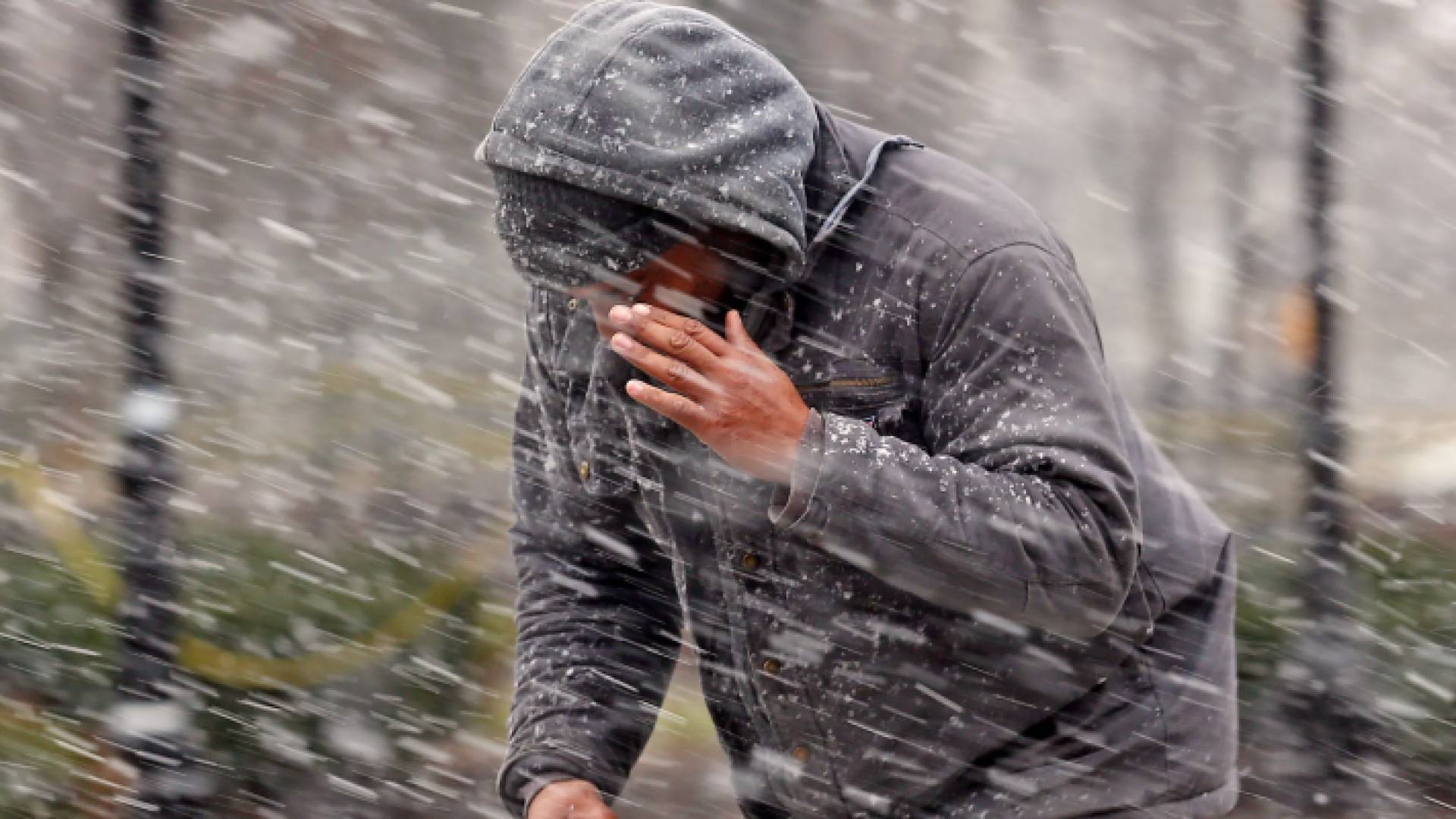 شخص يمشي وسط أمطار مخلوطة بالثلوج - تعبيرية