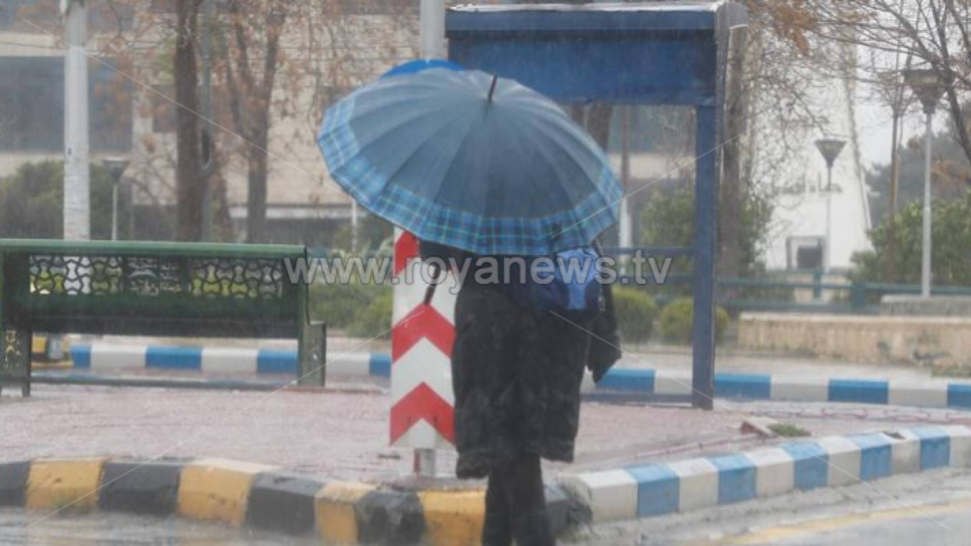 شخص يحمل مظلة في أحد شوارع العاصمة عمان