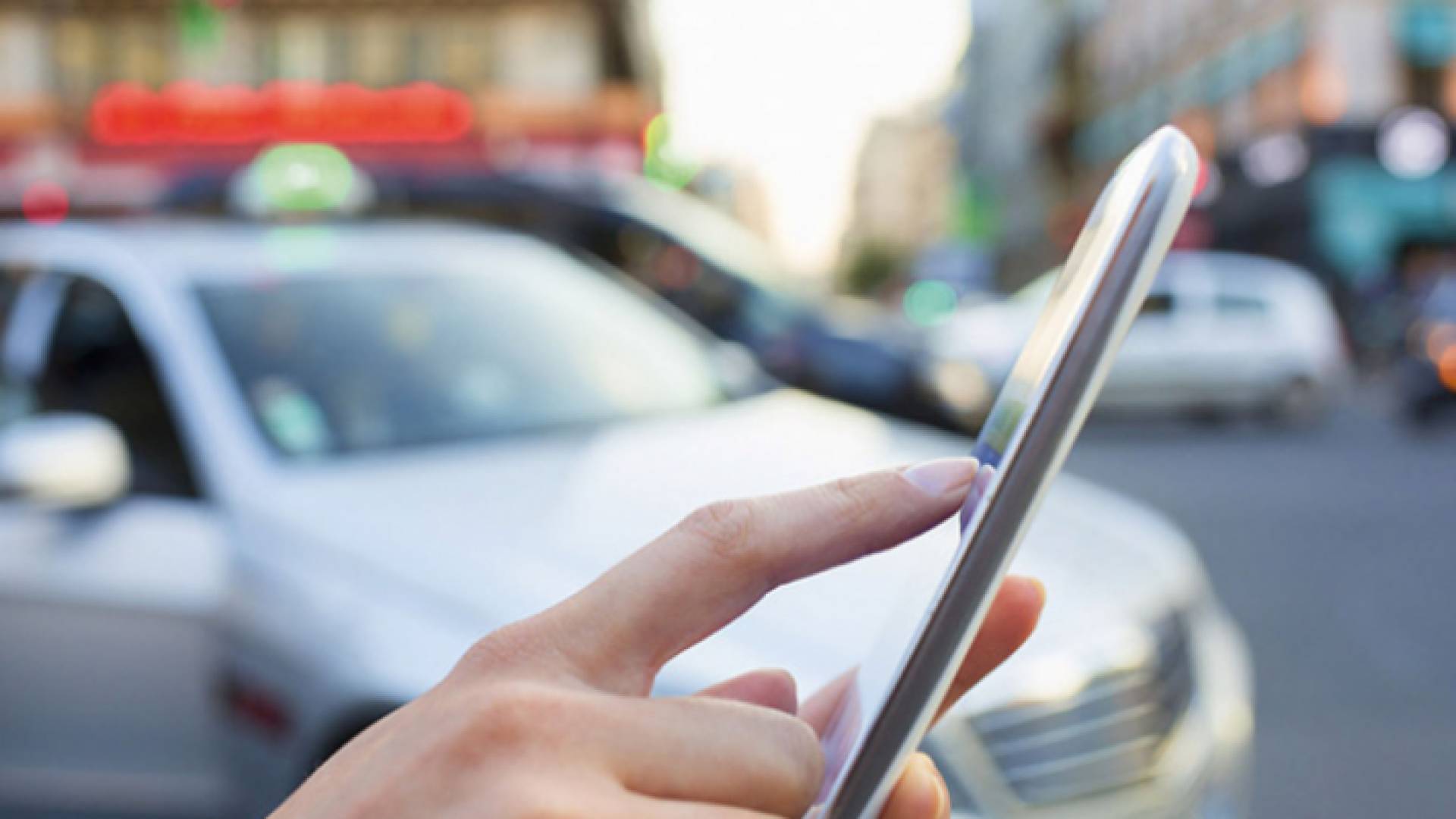 سيدة تطلب مركبة عبر تطبيقات النقل الذكية