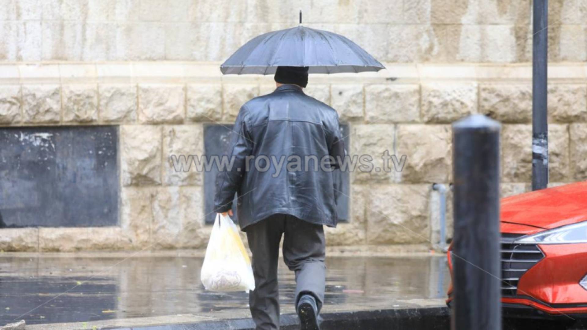 مسن يمشي في الأمطار