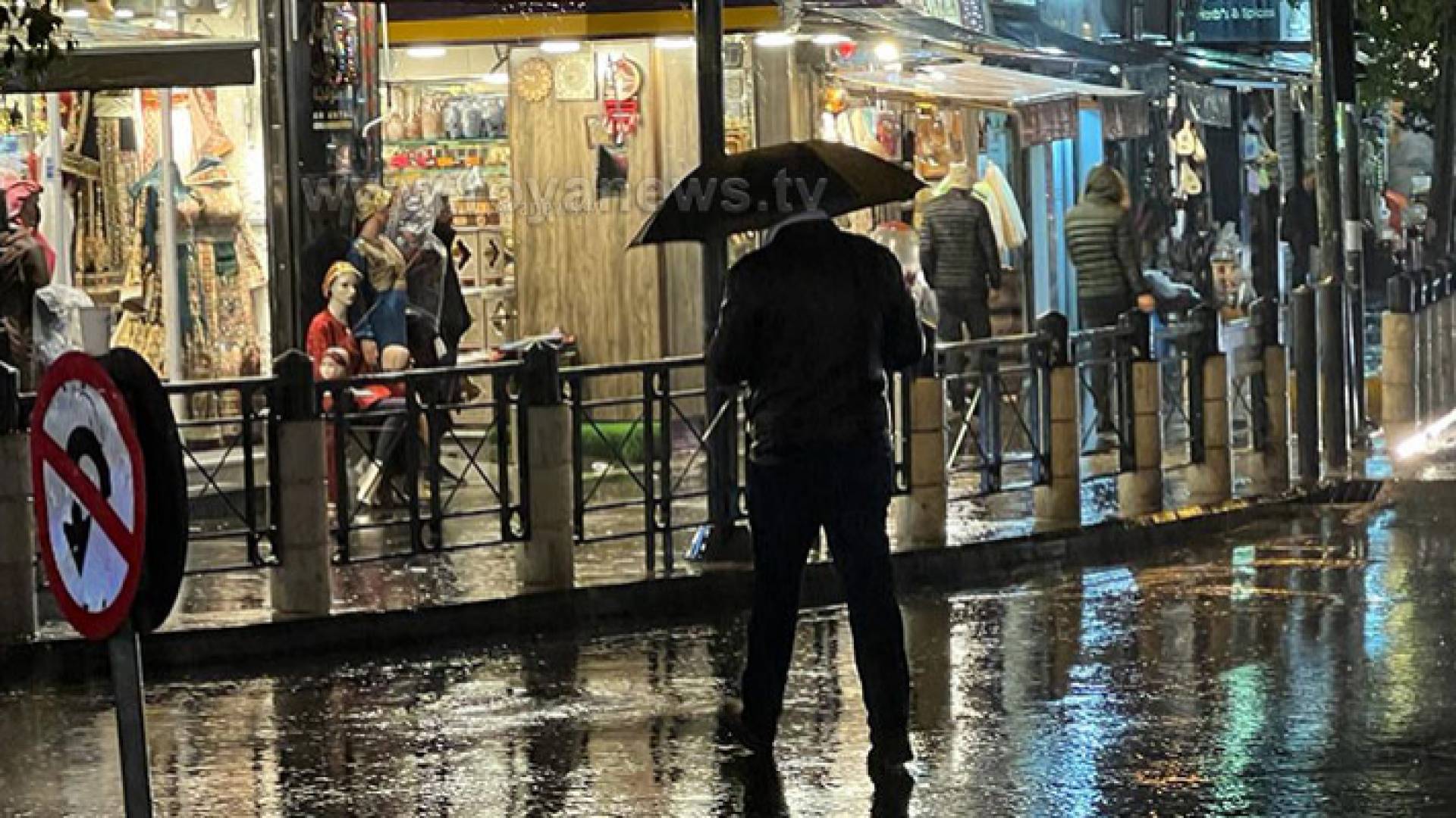 مواطن يحمل مظلية في منطقة وسط البلد