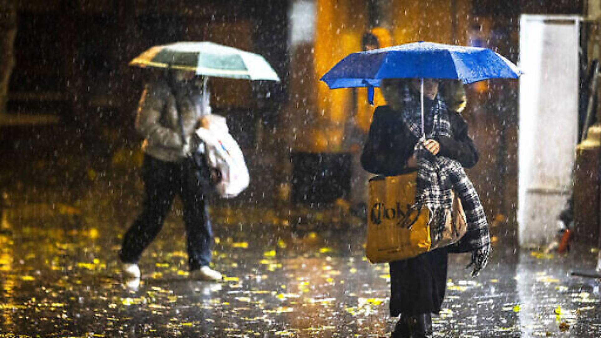 نساء يحملن مظليات خلال تساقط الأمطار